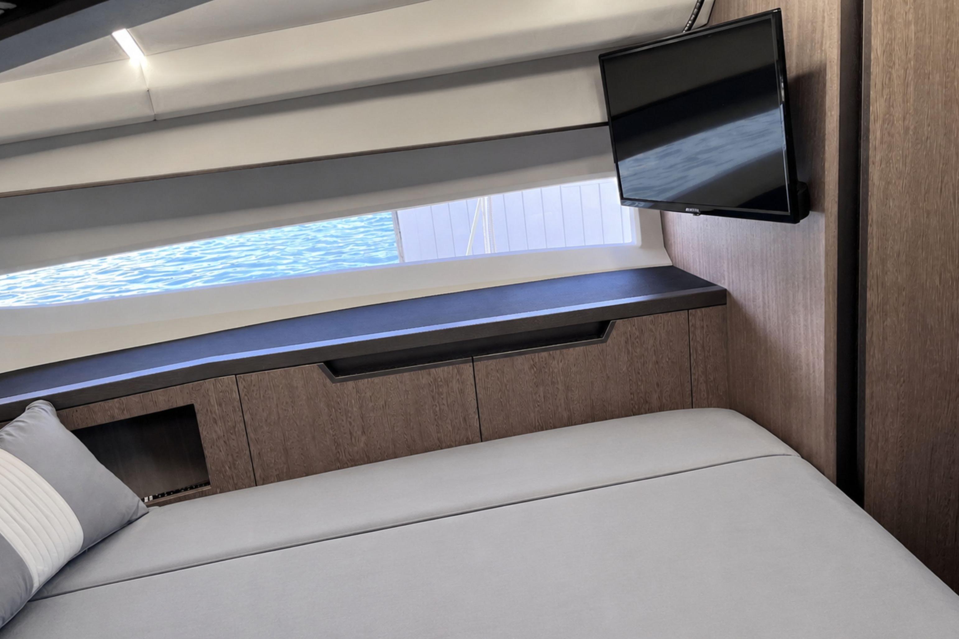 Luxurious interior of 2024 Galeon 425 HTS yacht with modern furnishings and a mounted TV.