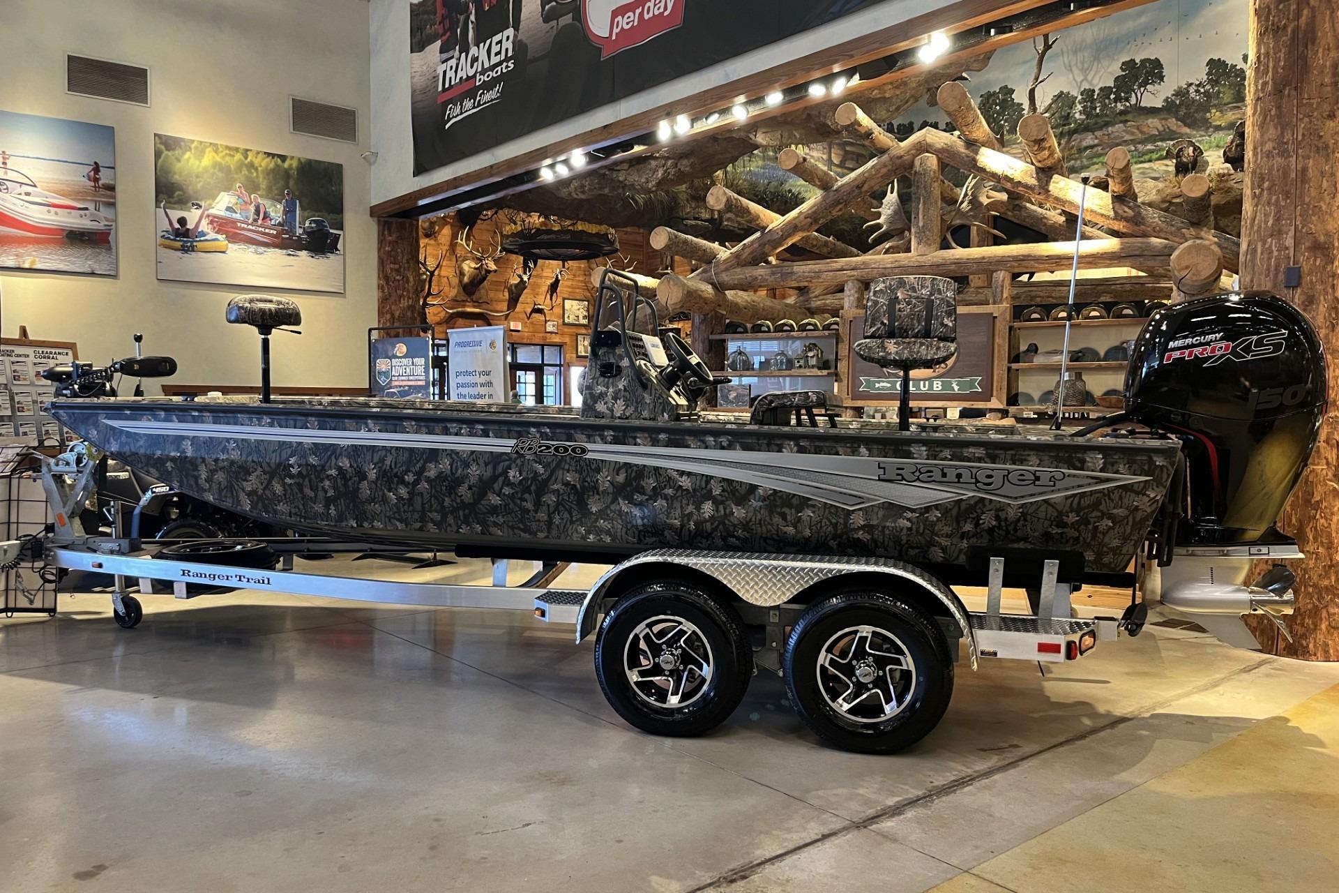 2026 Ranger RB200 boat displayed indoors, camouflage design, on a trailer.