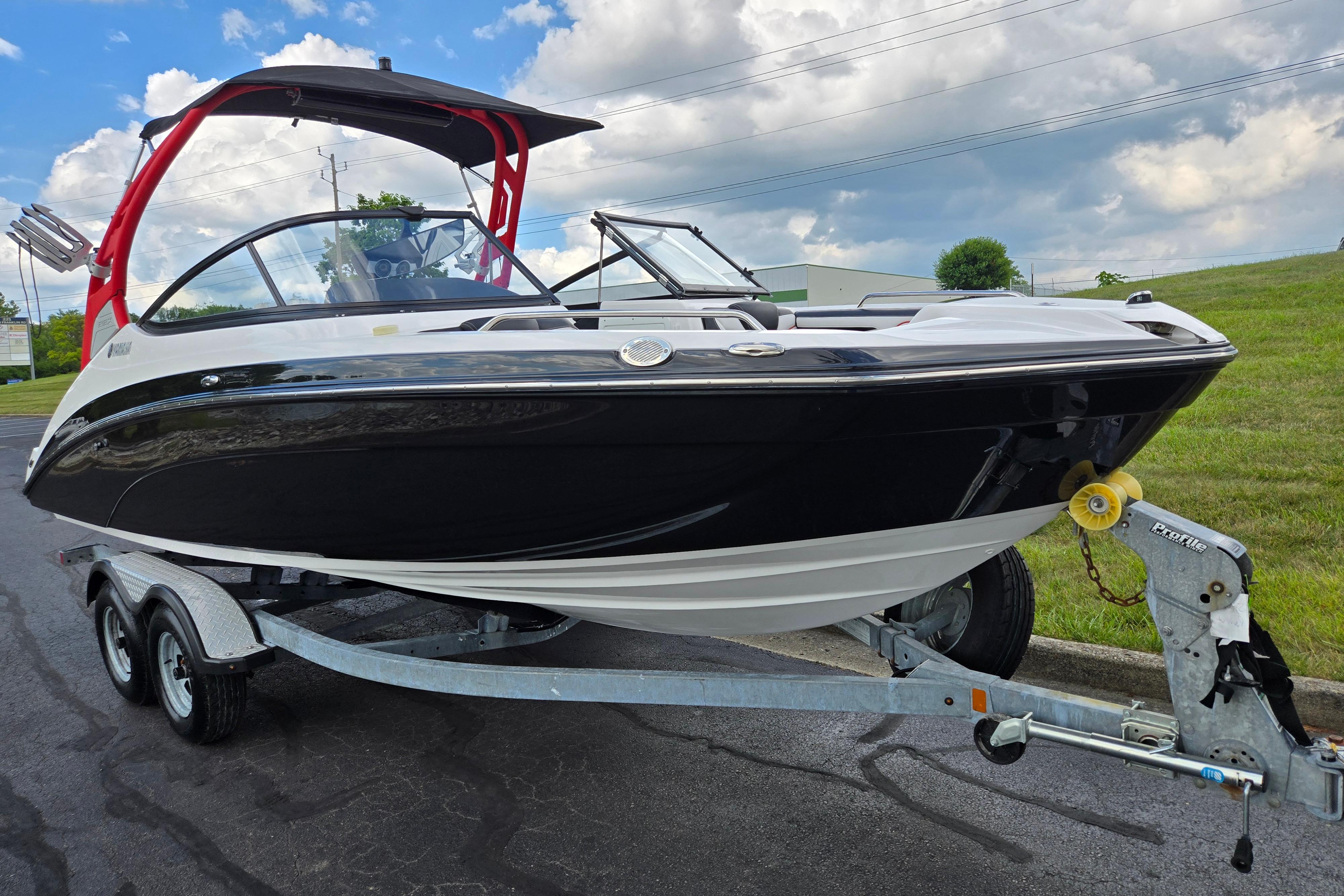 2018 Yamaha Boats 212X on trailer, black and white design, red wakeboard tower, parked outdoors.
