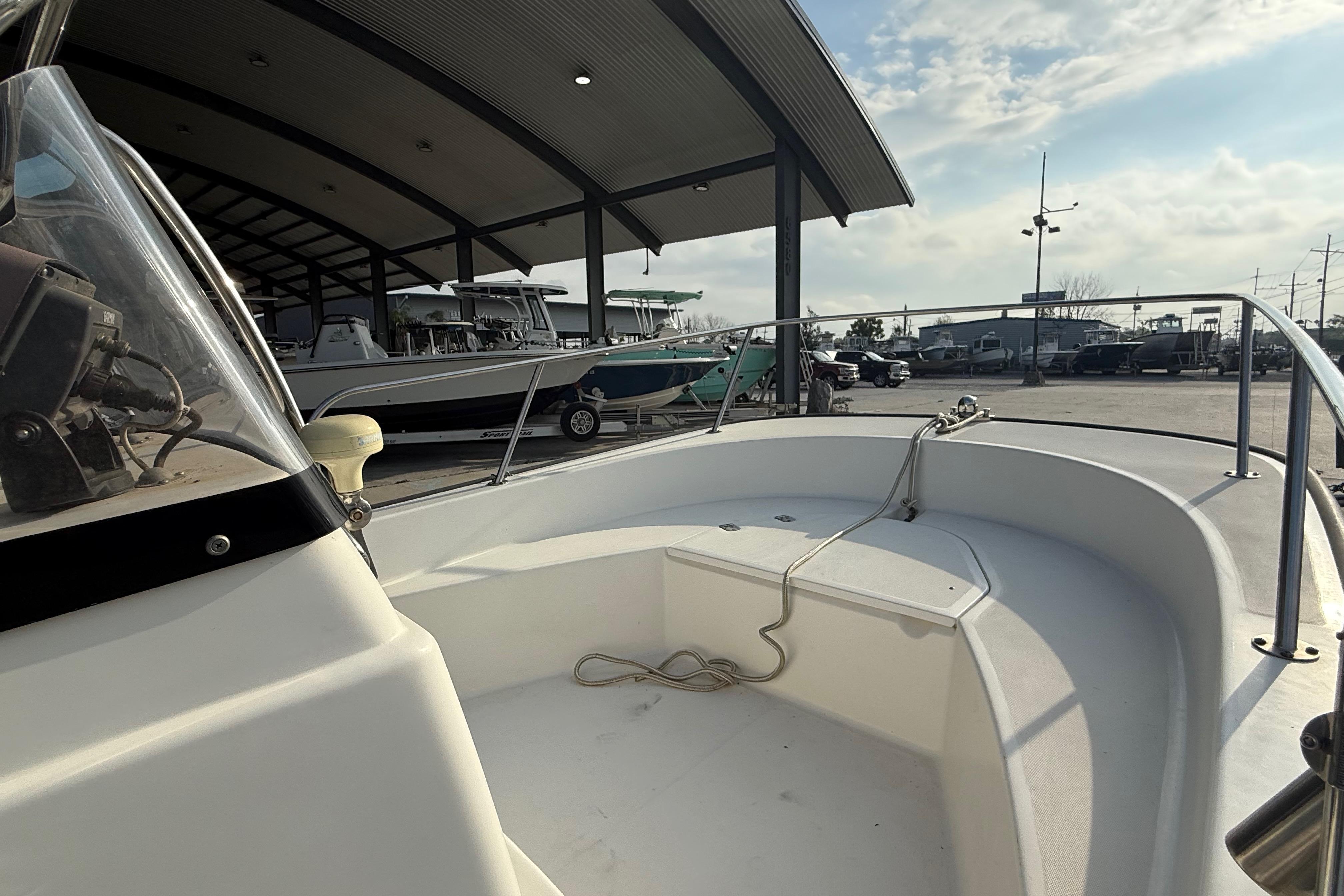 2005 Boston Whaler 17 Montauk boat docked under a covered marina.