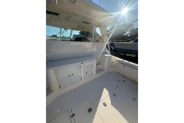 2010 Pursuit OS 375 Offshore boat interior with seating and storage, sunlit deck.