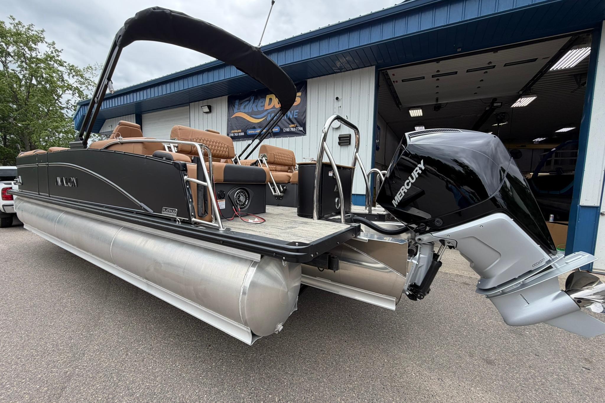 2026 Avalon Catalina Quad Lounge Shift pontoon boat with Mercury engine, docked outside.