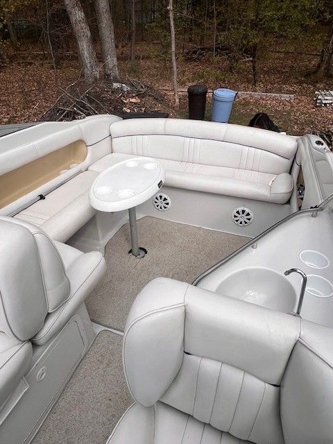 Interior of a 1999 Crownline 266 CCR boat with white leather seating.
