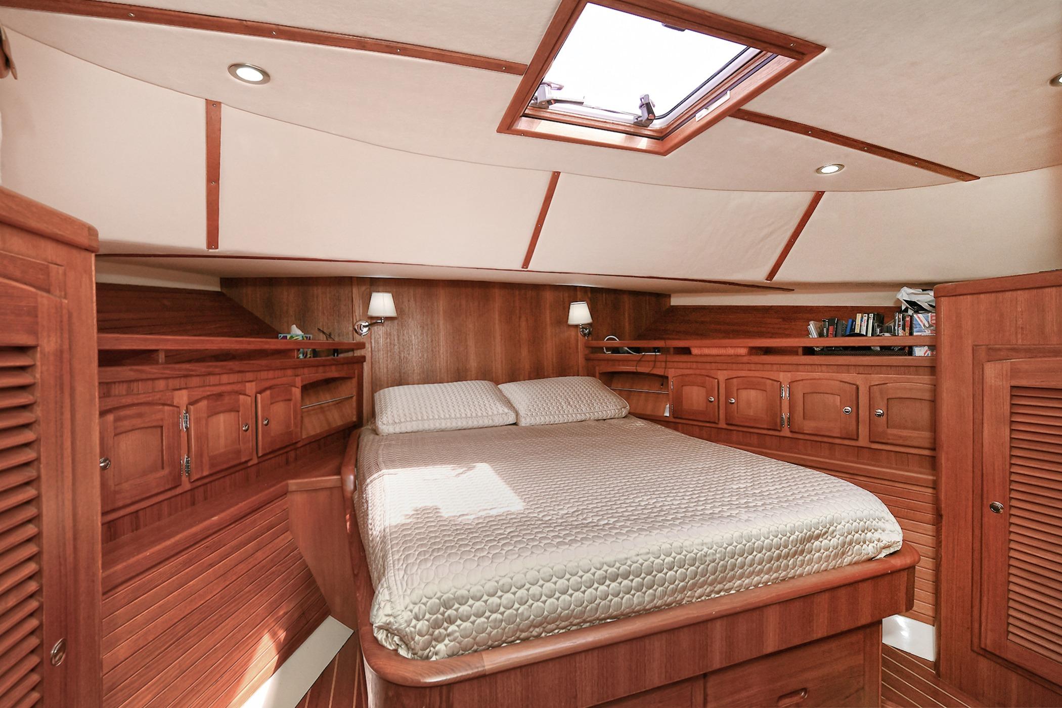 Luxurious 2005 San Juan Downeast Express cabin with wood finish and cozy bed.