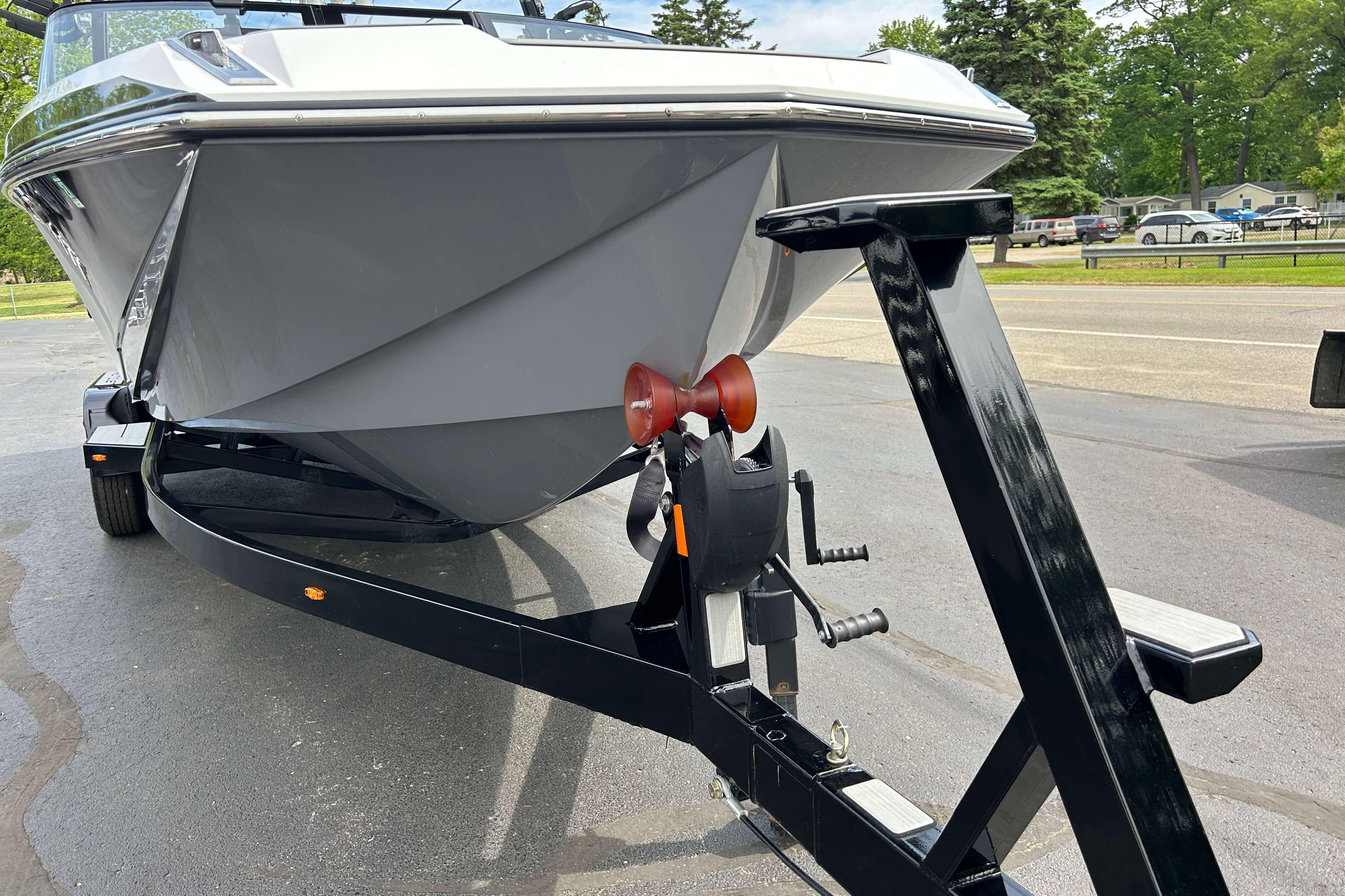 2021 Nautique Super Air Nautique GS24 boat on trailer, parked outdoors.