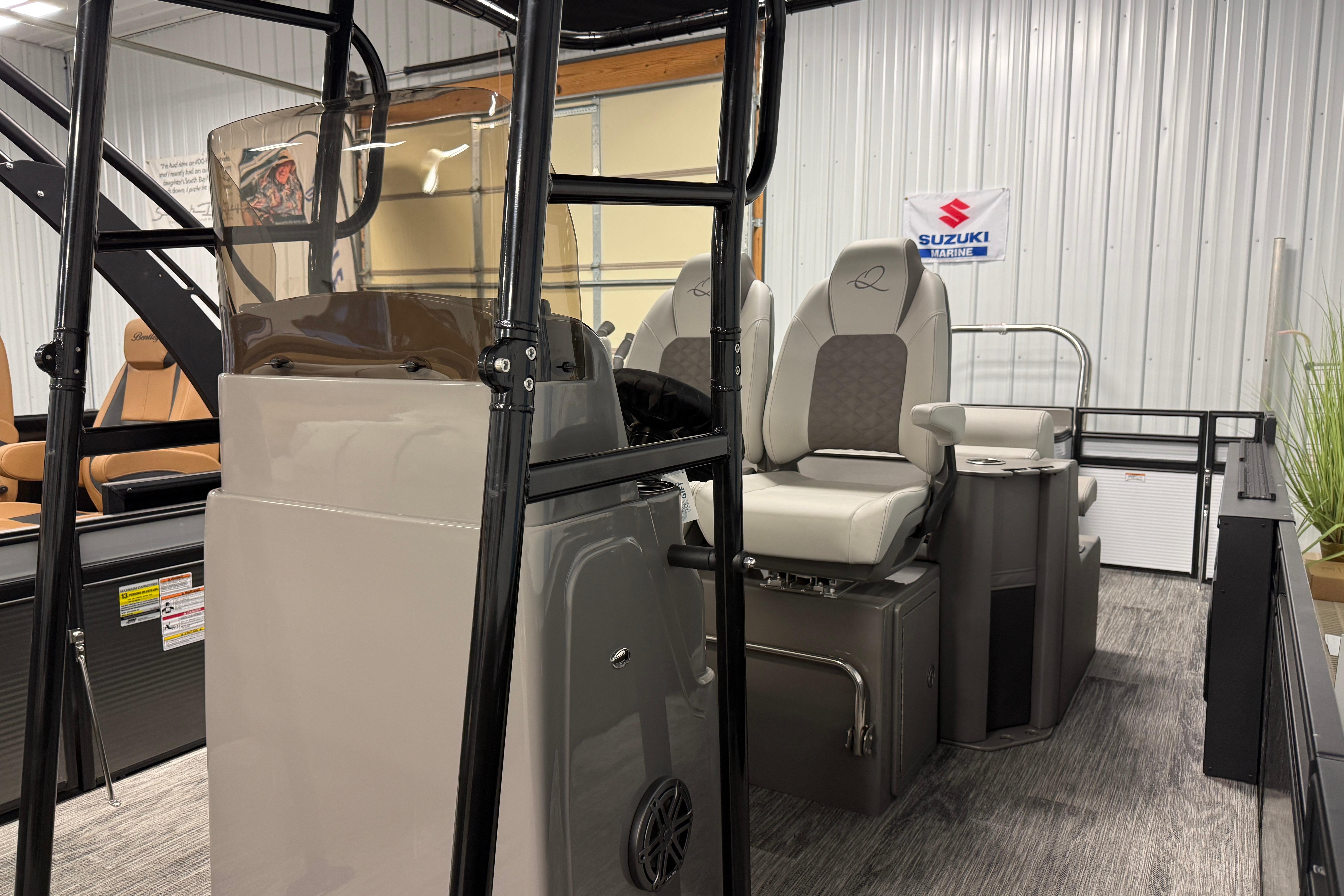 2026 Qwest M-Class 22 Pro Sport boat interior with seating and console, displayed indoors.