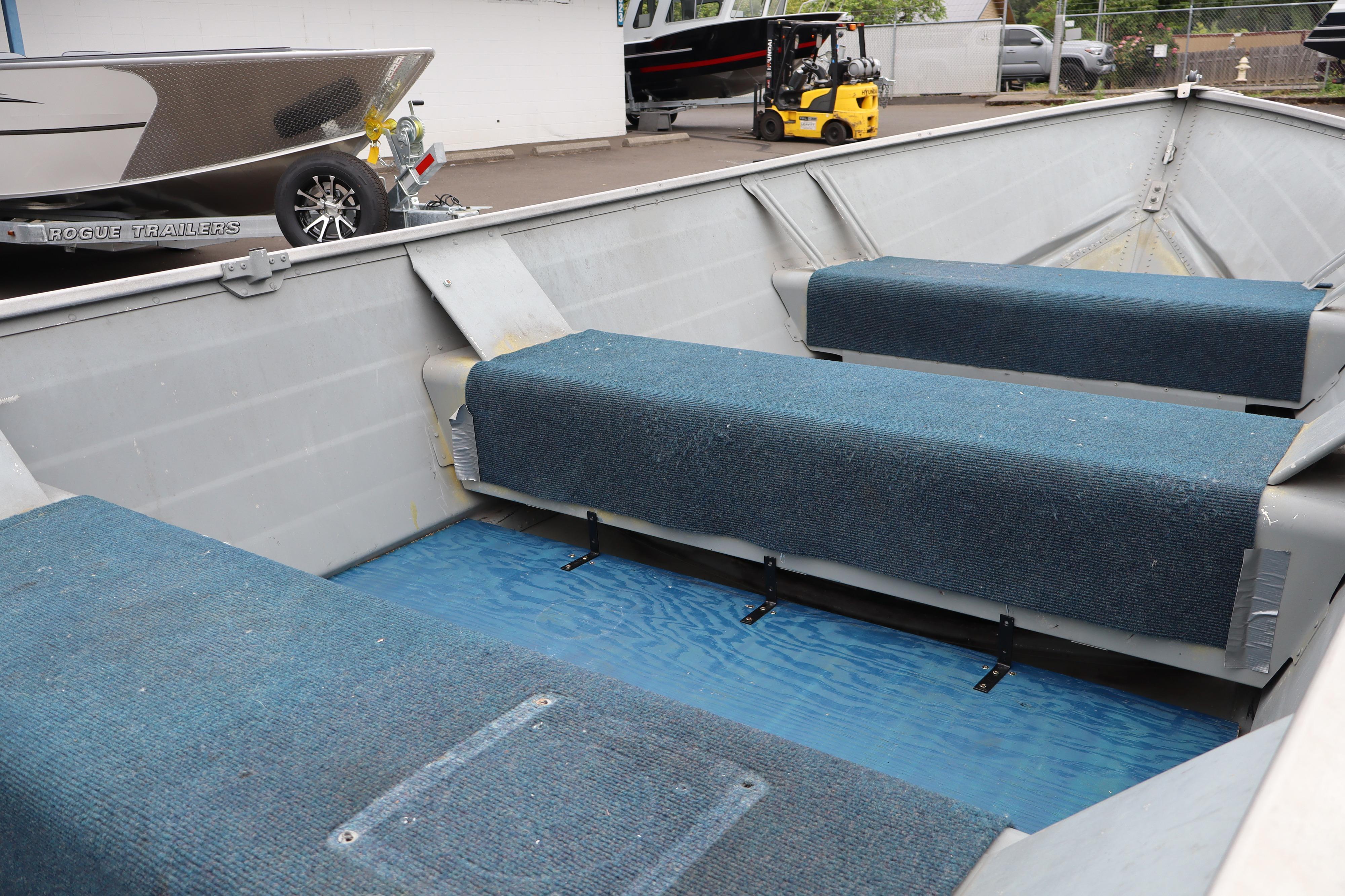 2003 Smoker Craft Alaskan 13 boat interior with blue carpeted seating and aluminum structure.