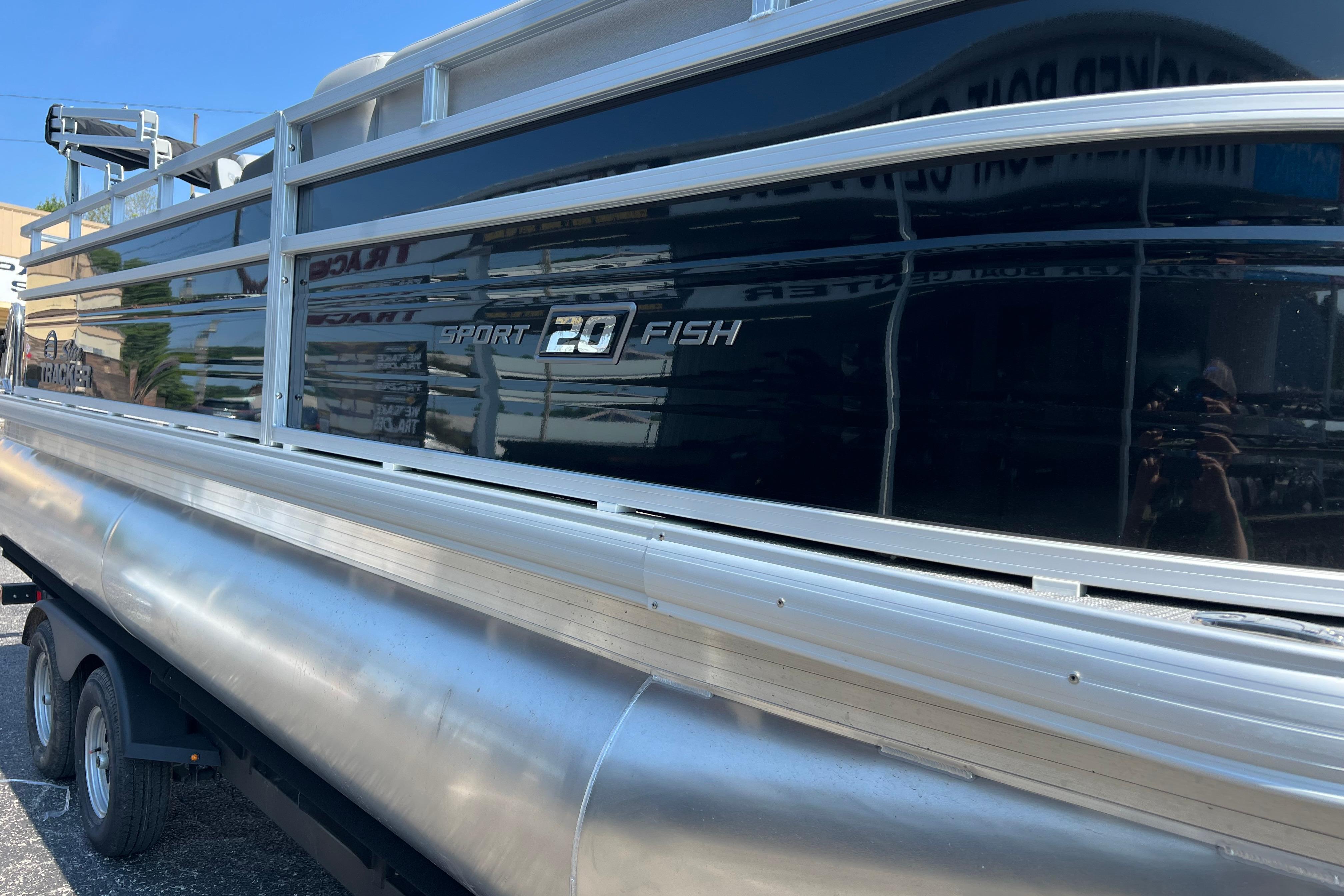 2026 Sun Tracker SportFish 20 DLX pontoon boat on trailer, side view.