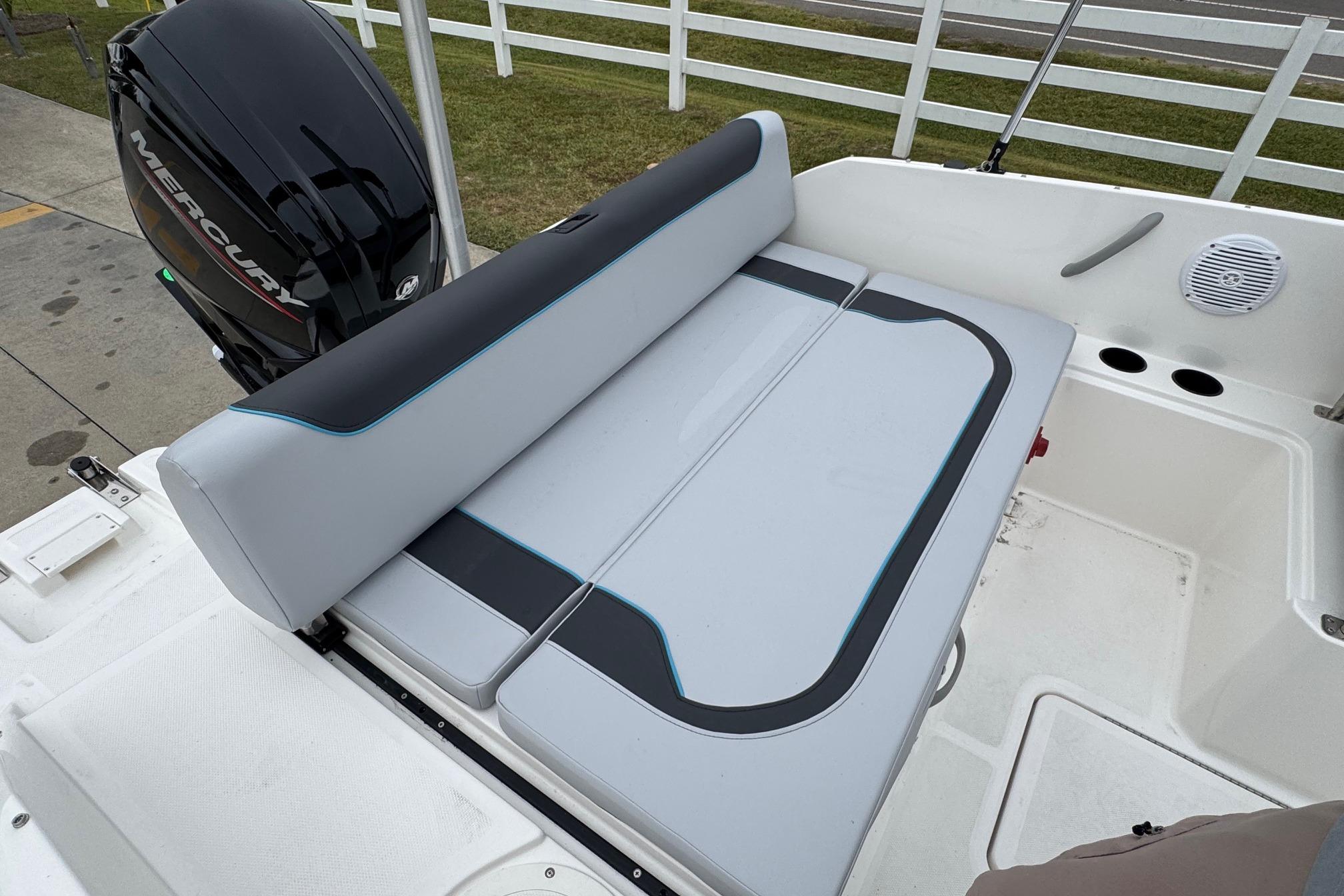 2026 Bayliner M19 boat interior with cushioned seating and Mercury outboard motor.