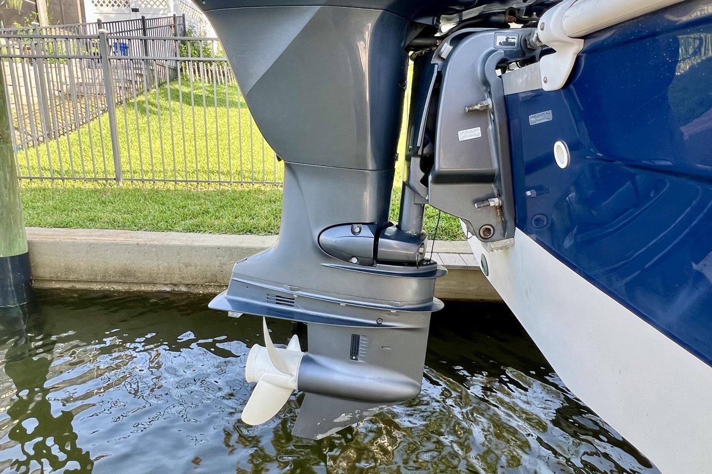 2013 Hurricane SunDeck 187 OB boat motor in water, showcasing propeller and hull design.