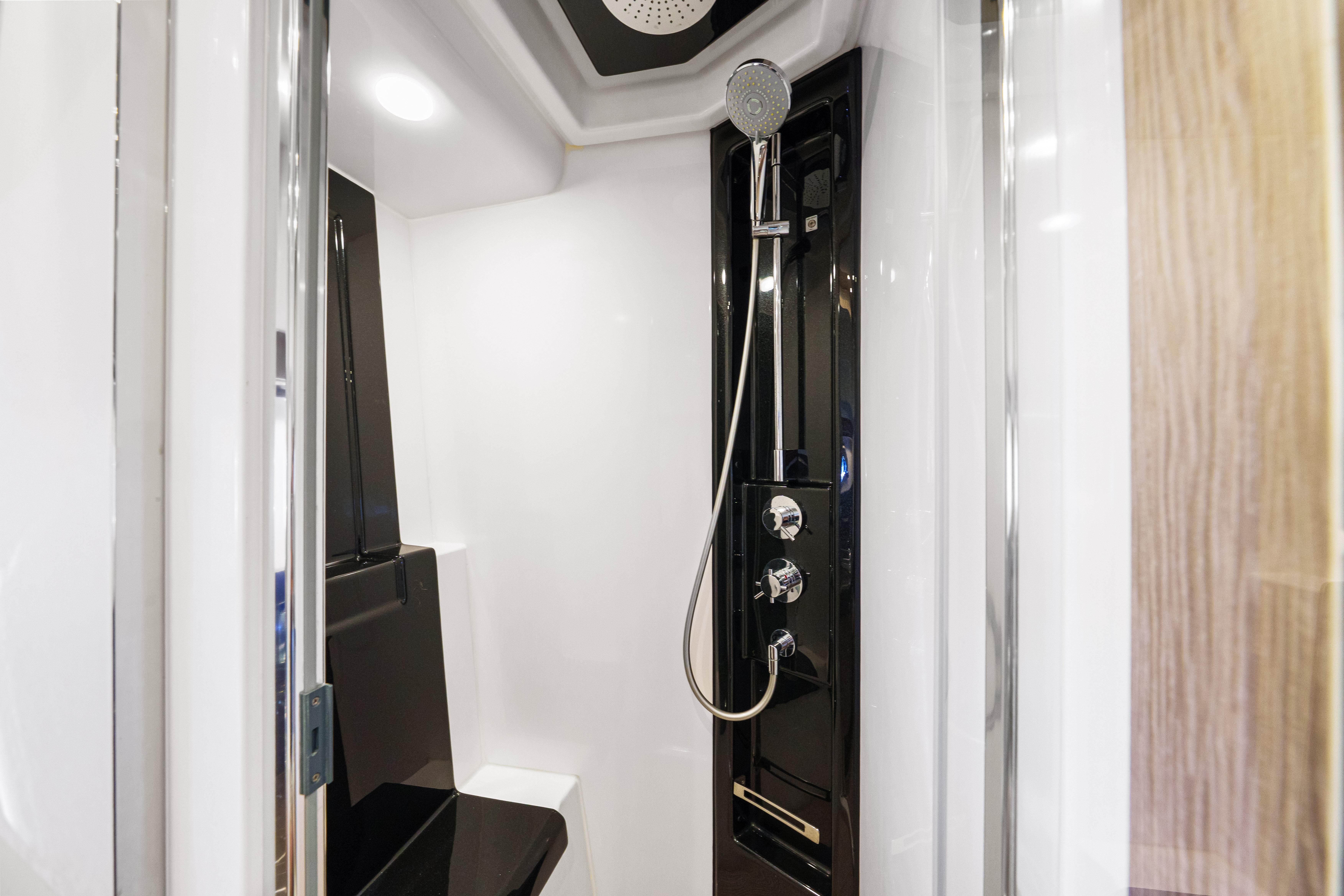 Luxurious shower in 2020 Azimut S6 yacht, featuring sleek black and white design.