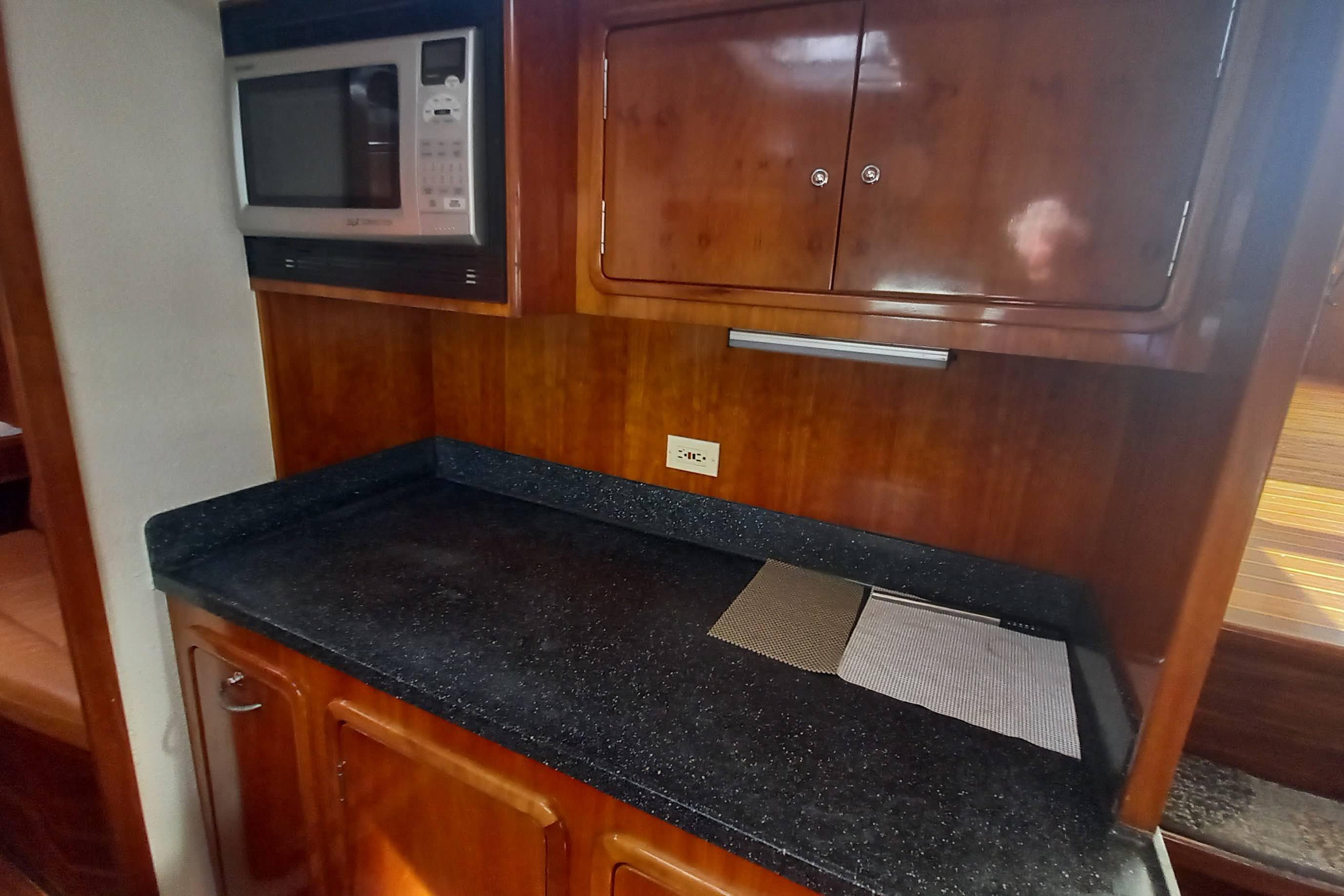 Galley kitchen in 2003 St Francis 48 yacht with microwave and wooden cabinetry.