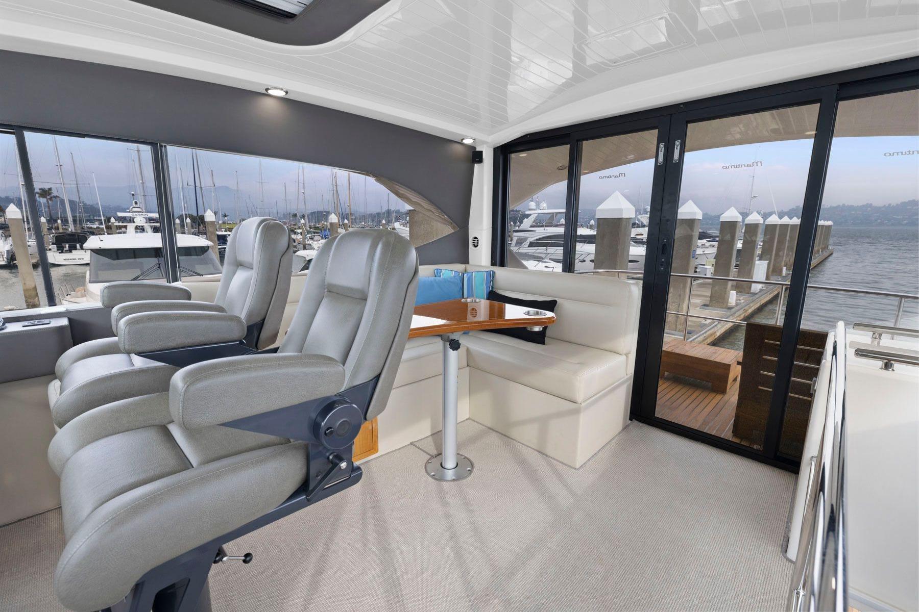 Luxurious interior of 2014 Maritimo M50 yacht with plush seating and marina view.