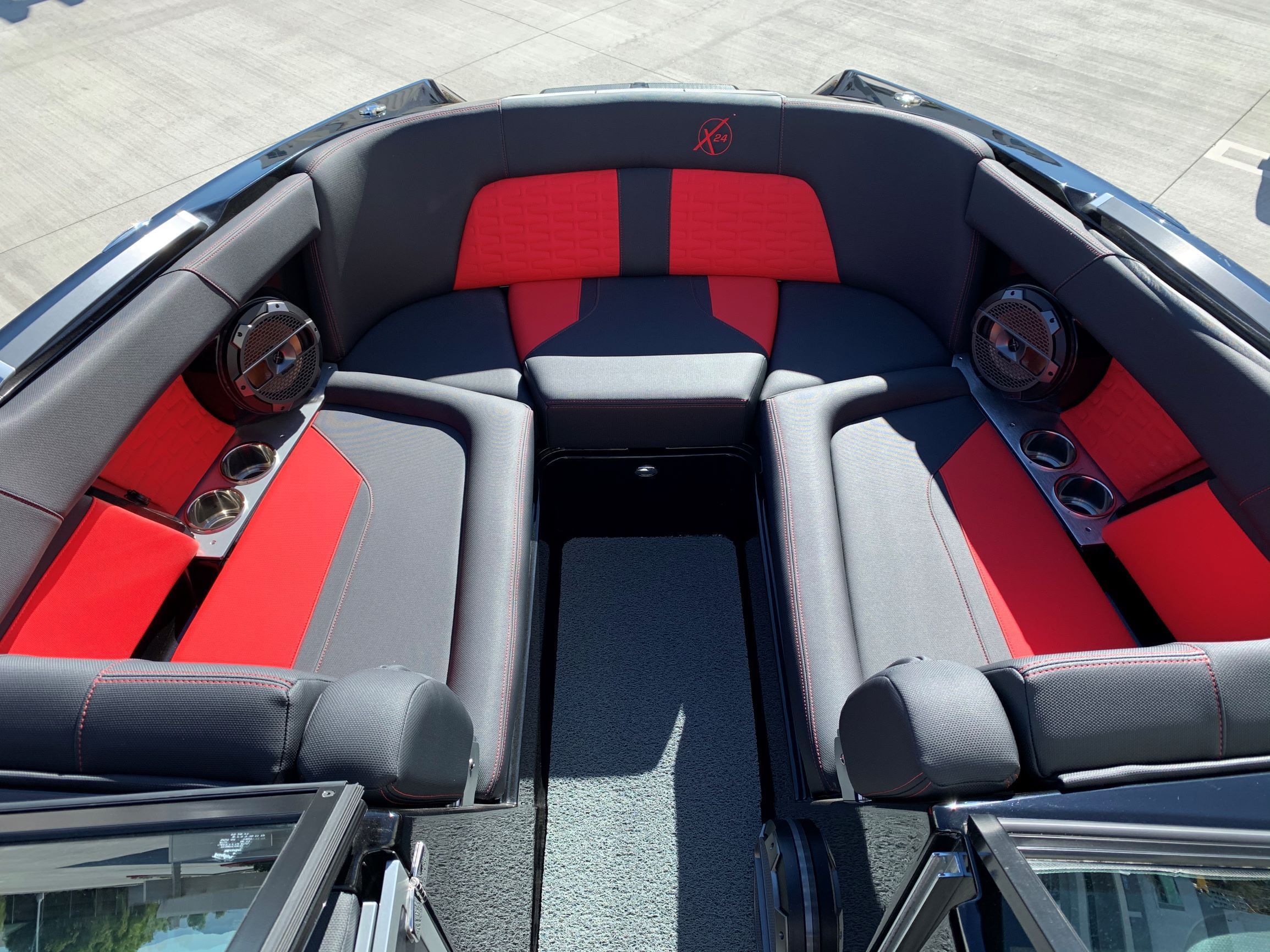 The image shows the interior of a 2020 MasterCraft X24 boat with red and gray seating.