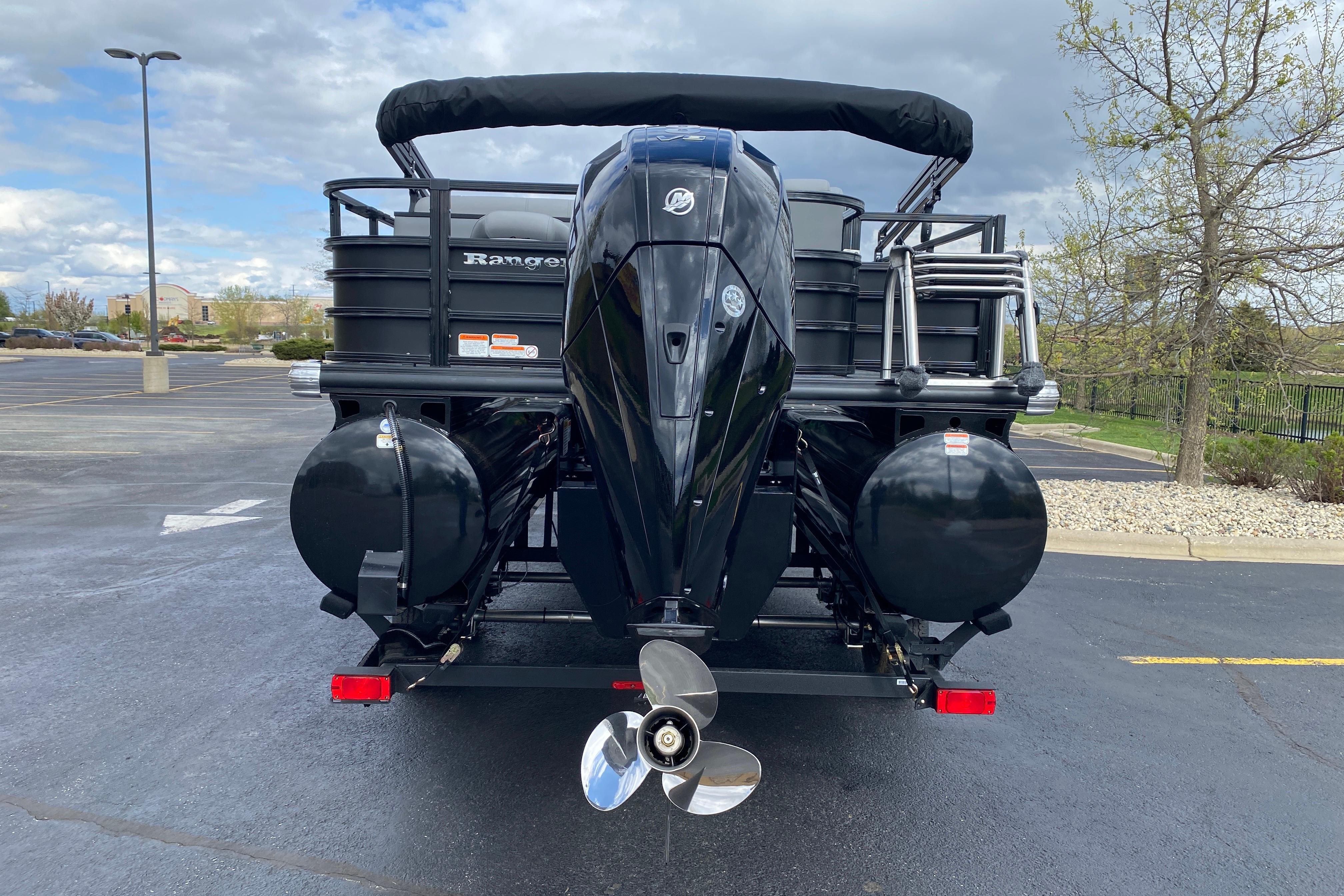 2026 Ranger 223FC boat with powerful outboard motor in a parking lot.