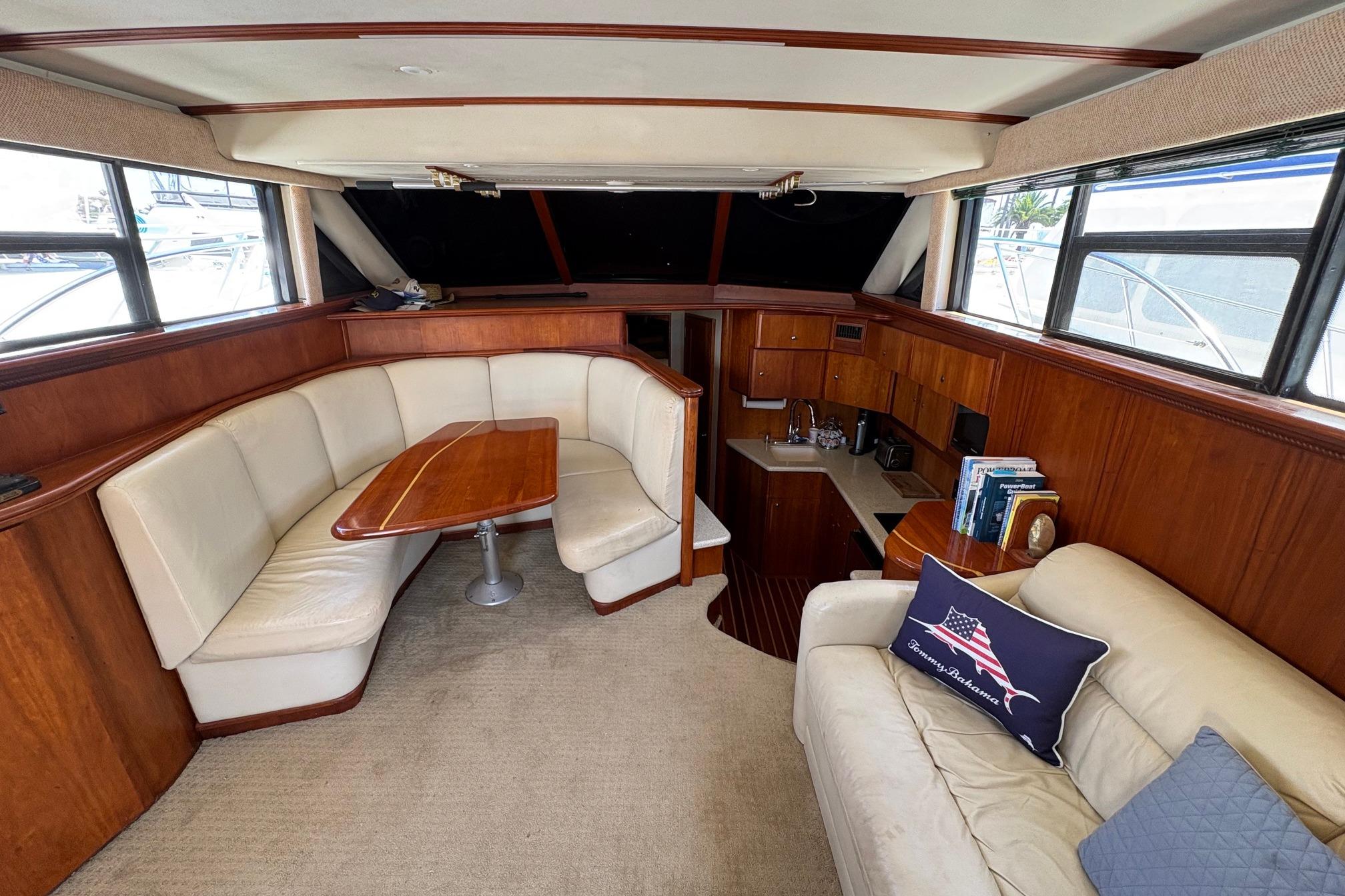 Interior of 2000 Silverton 42 Convertible yacht with seating and kitchenette.