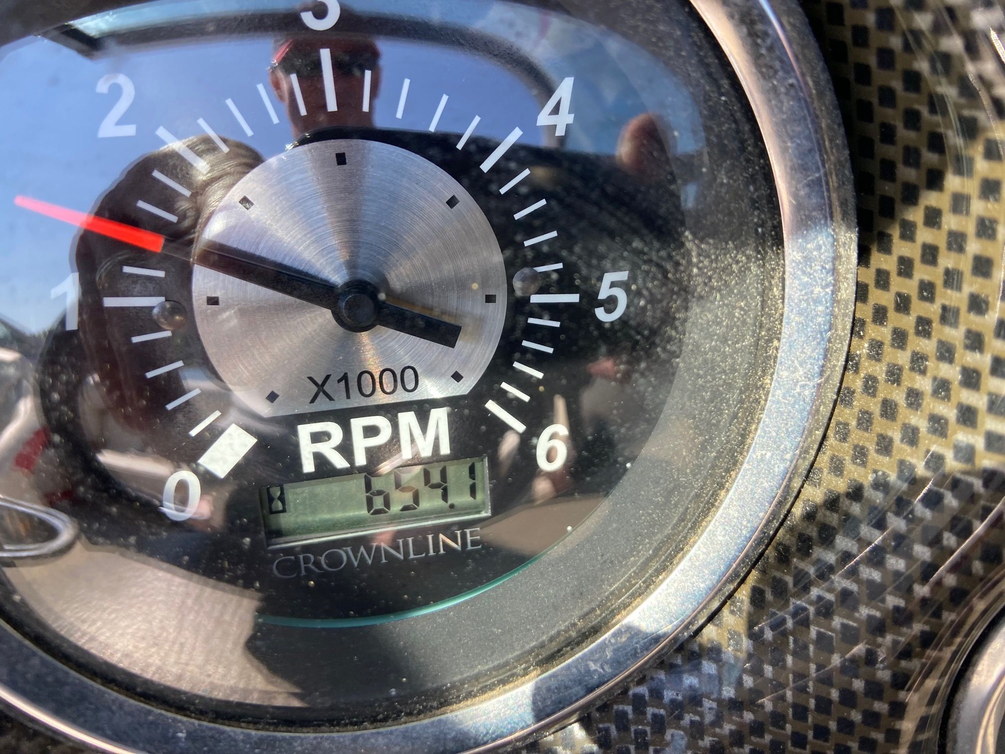 Close-up of a tachometer showing 654 RPM.