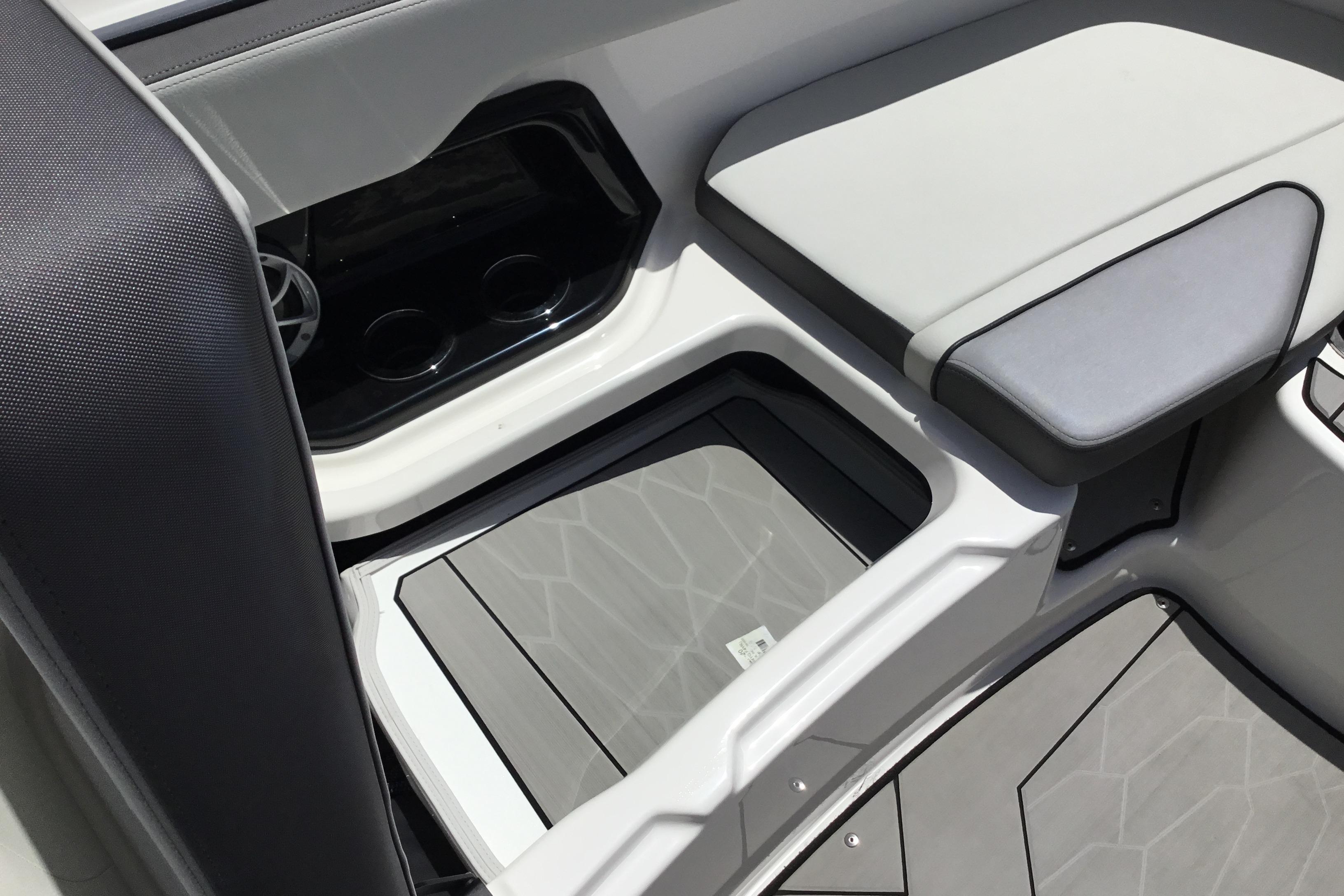 Interior seating and storage of 2023 Yamaha Boats 252XE, featuring sleek design and cup holders.