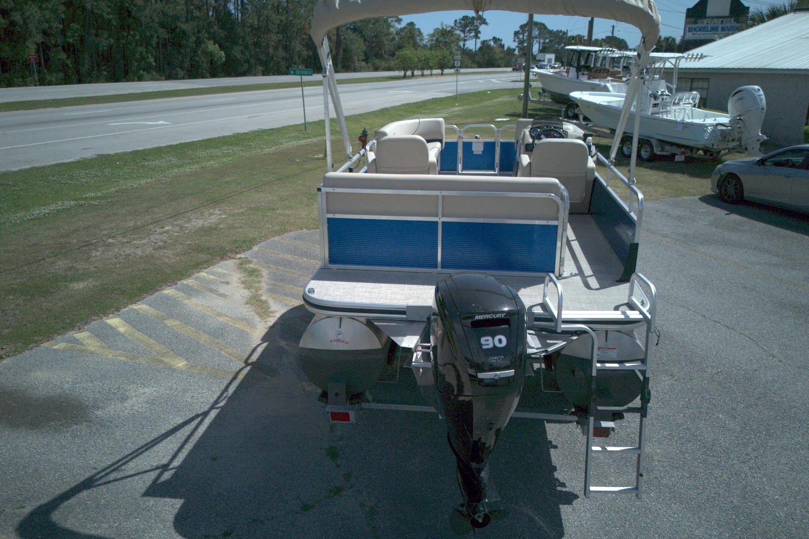 2024 Lowe Ultra 200 Cruise pontoon boat with Mercury 90 engine, parked outdoors.
