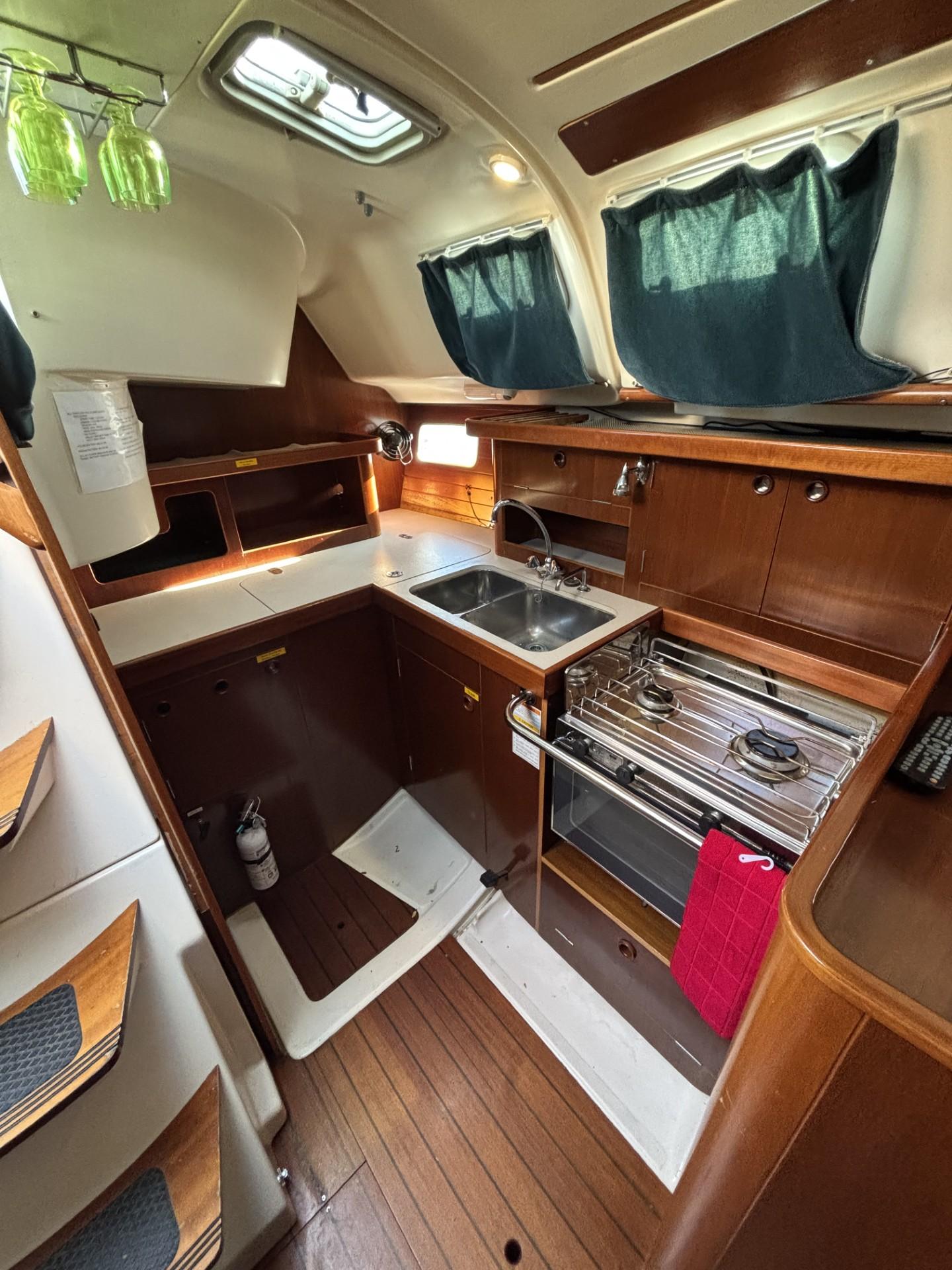 1997 Beneteau Oceanis 351 yacht kitchen with wood cabinetry and modern appliances.
