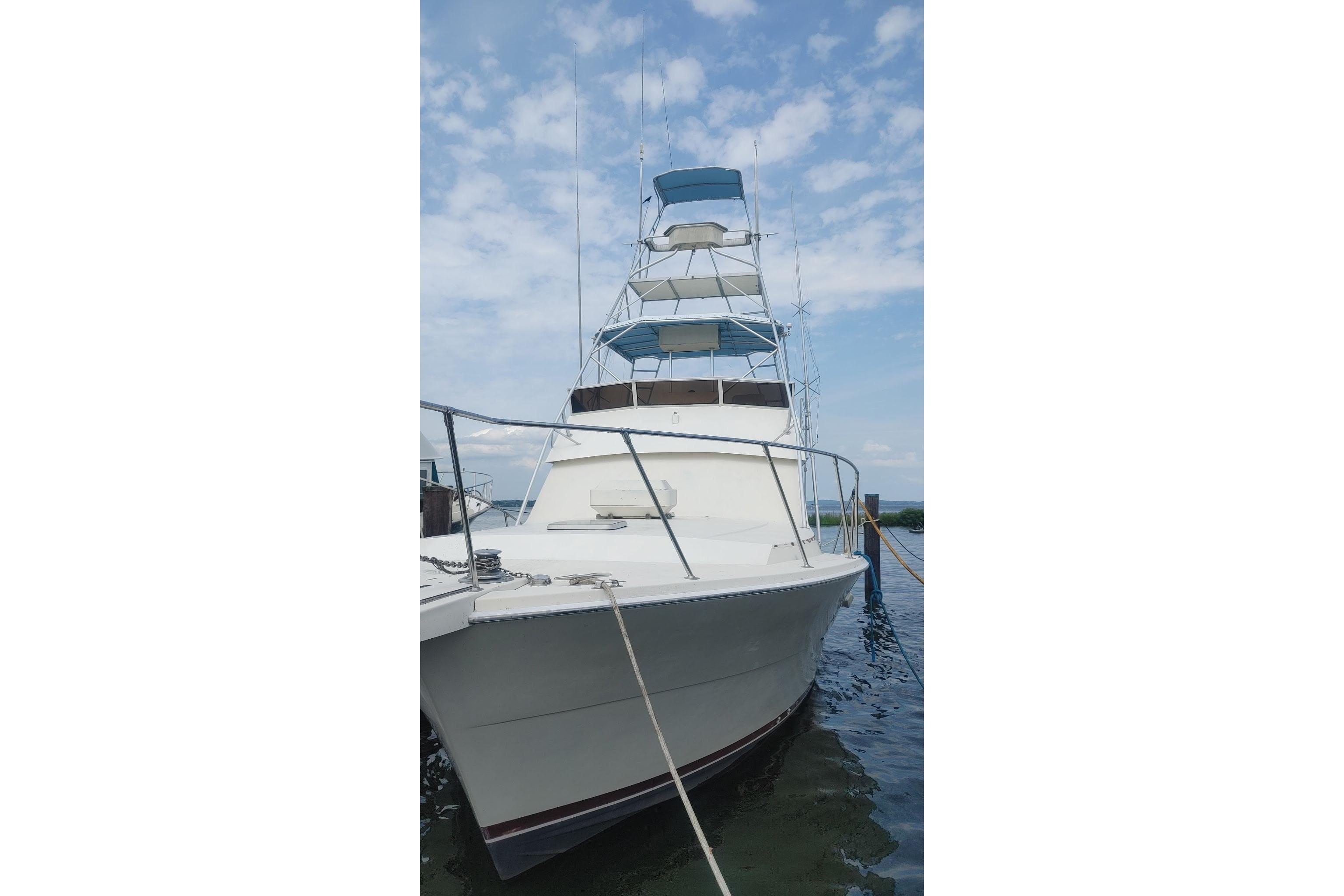 1986 Viking Sportfish 41 boat docked under a partly cloudy sky.