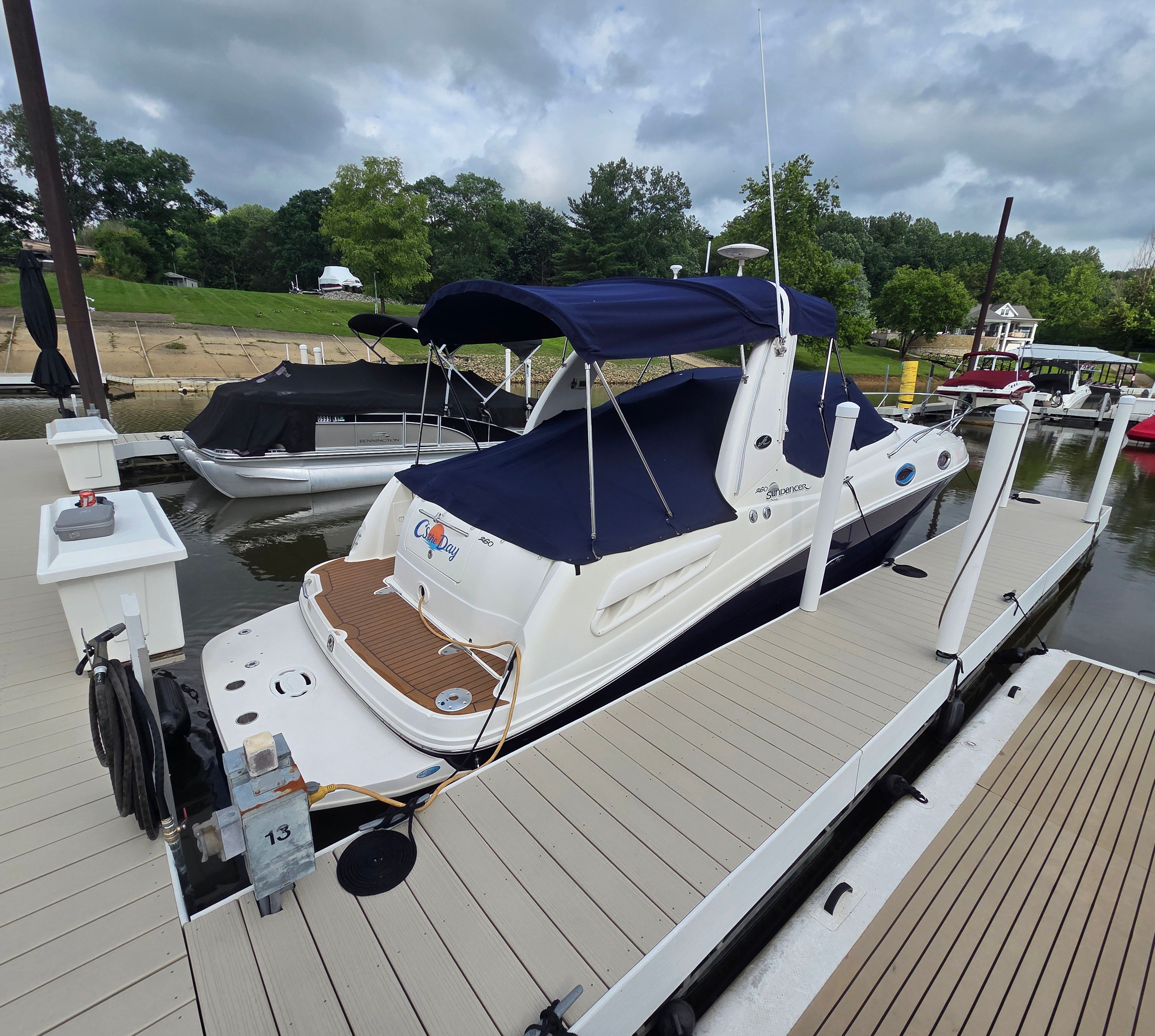 2005 Sea Ray Sundancer 260 at a dock with a blue cover.