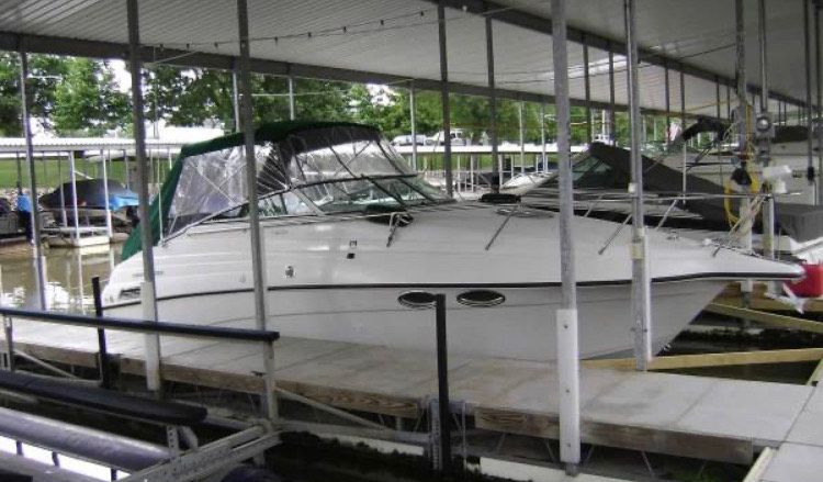 A 1999 Crownline 265 CR docked in a covered marina.