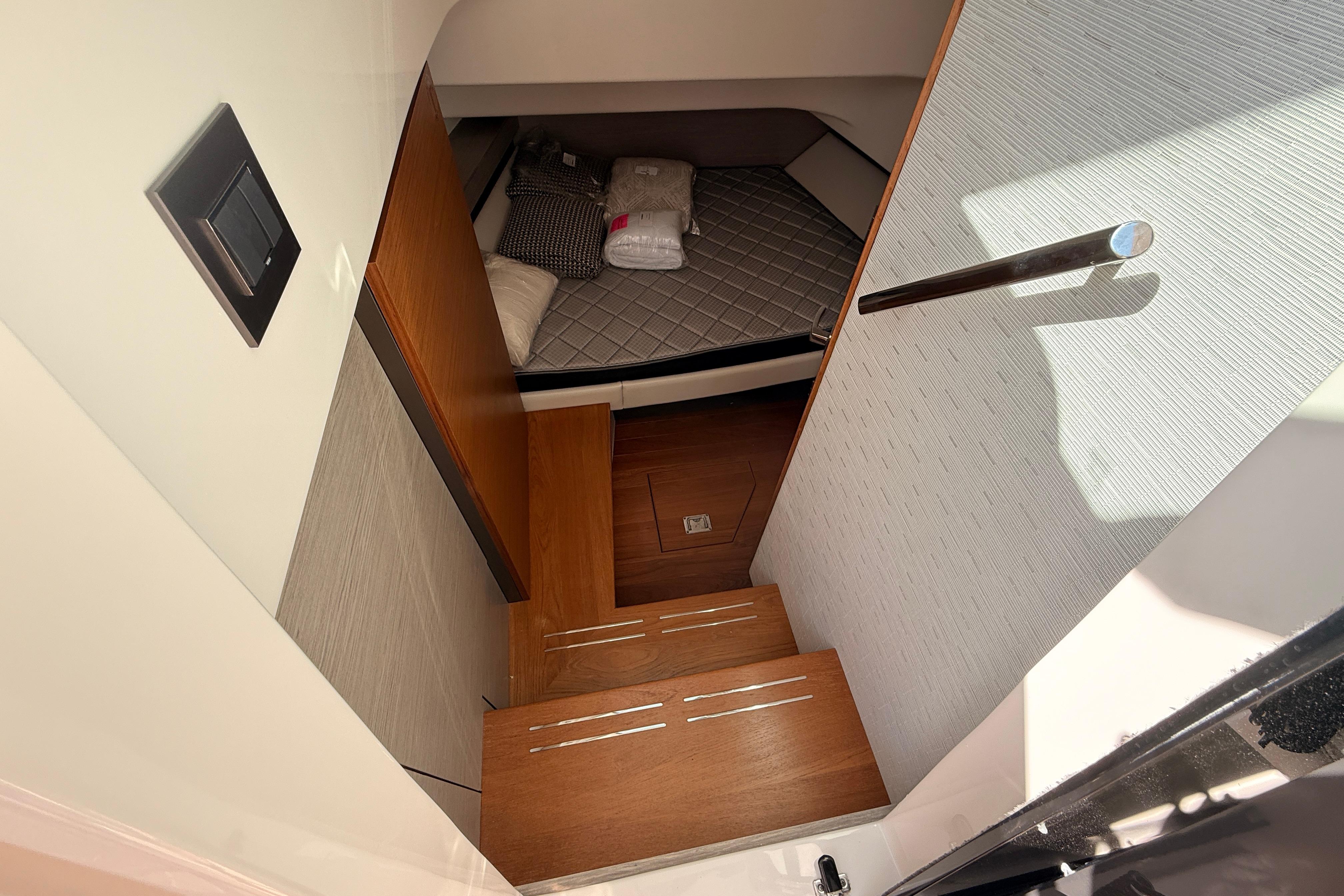 2024 Tiara Yachts 34 LS cabin interior with wooden steps and cozy bedding.