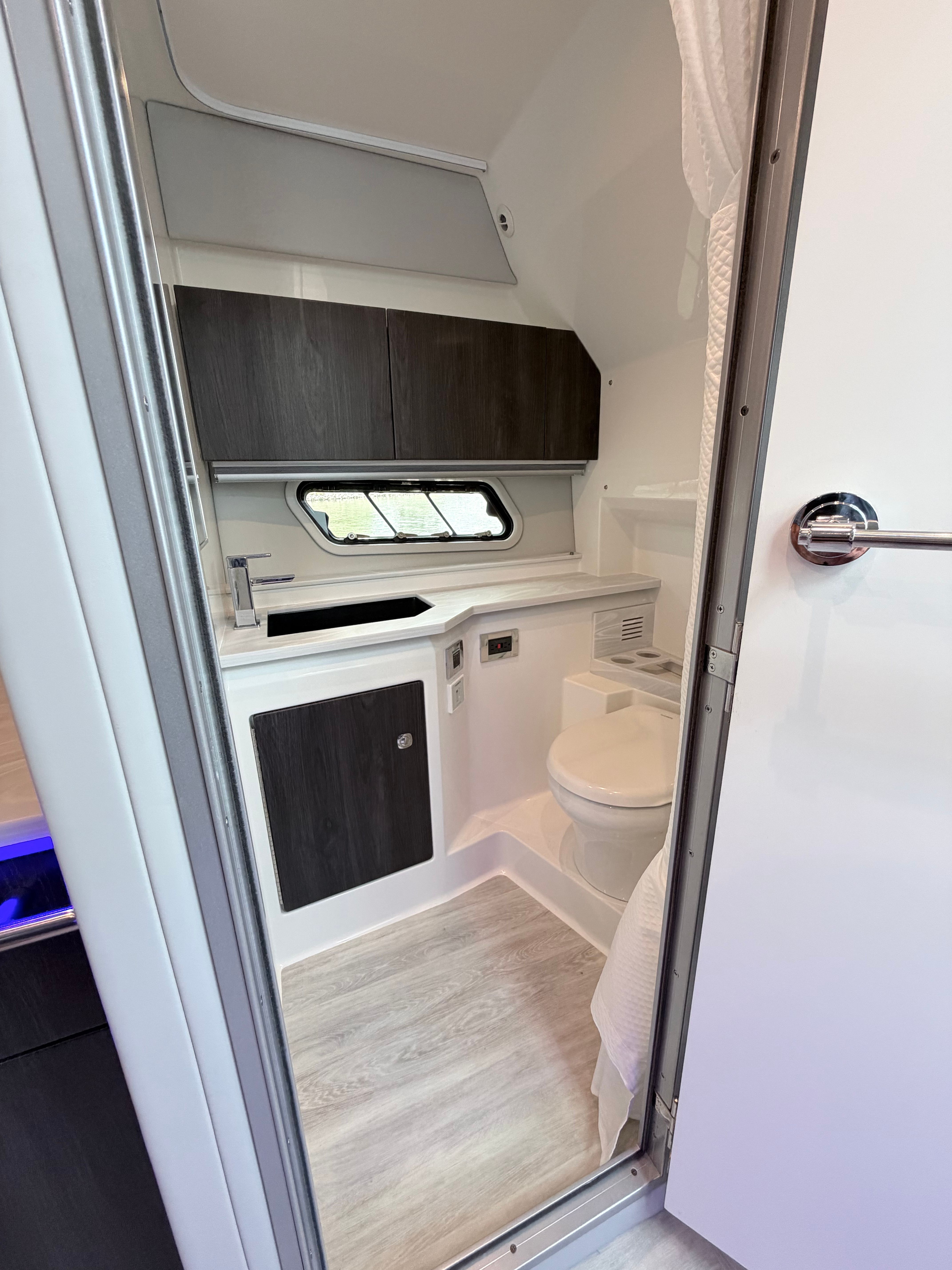 Interior of the 2023 Formula 400 Super Sport Crossover featuring a modern bathroom with wood accents.