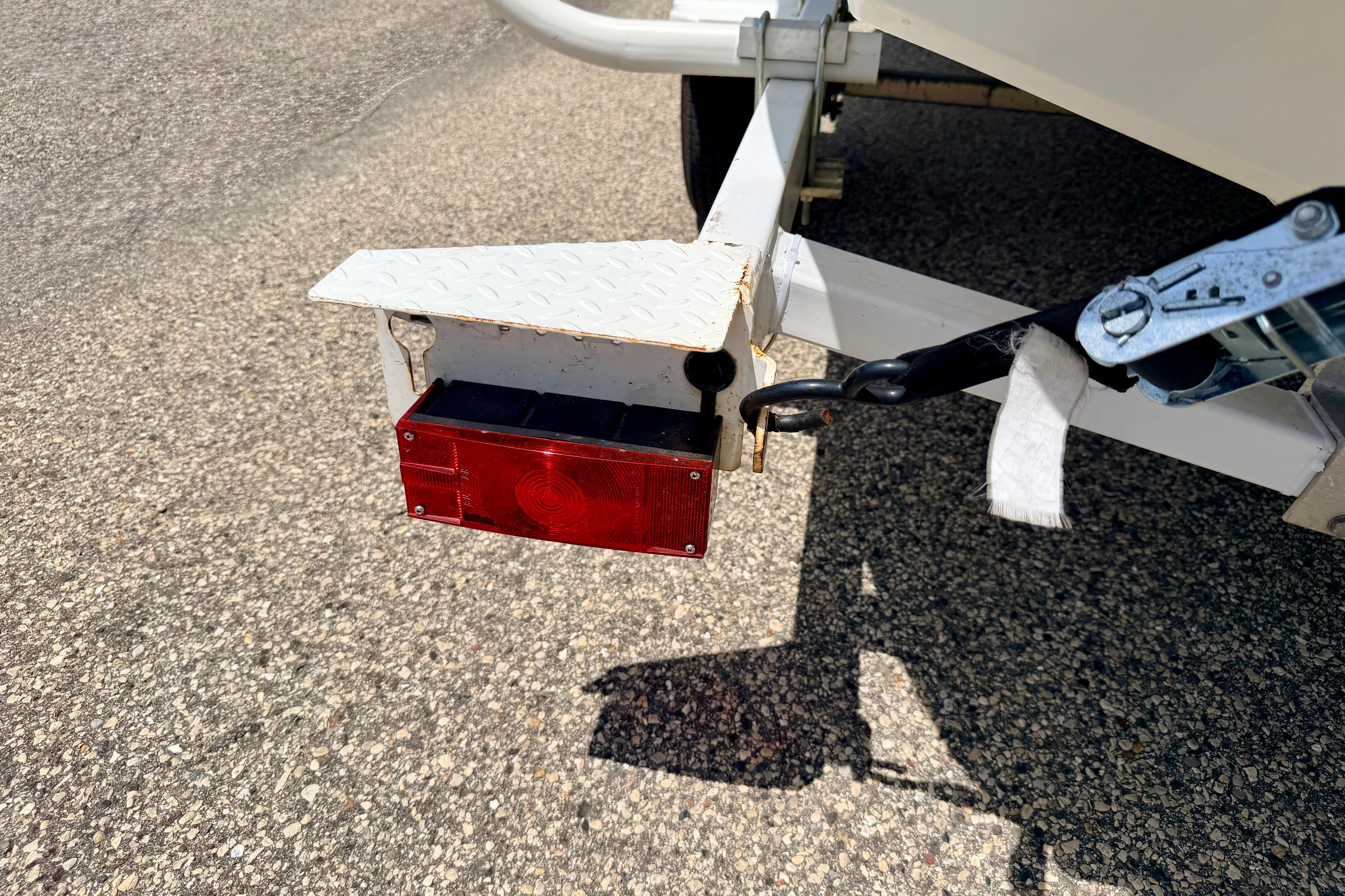 Trailer light and hitch of a 2004 Bombardier SEADOO Utopia 185 on asphalt.