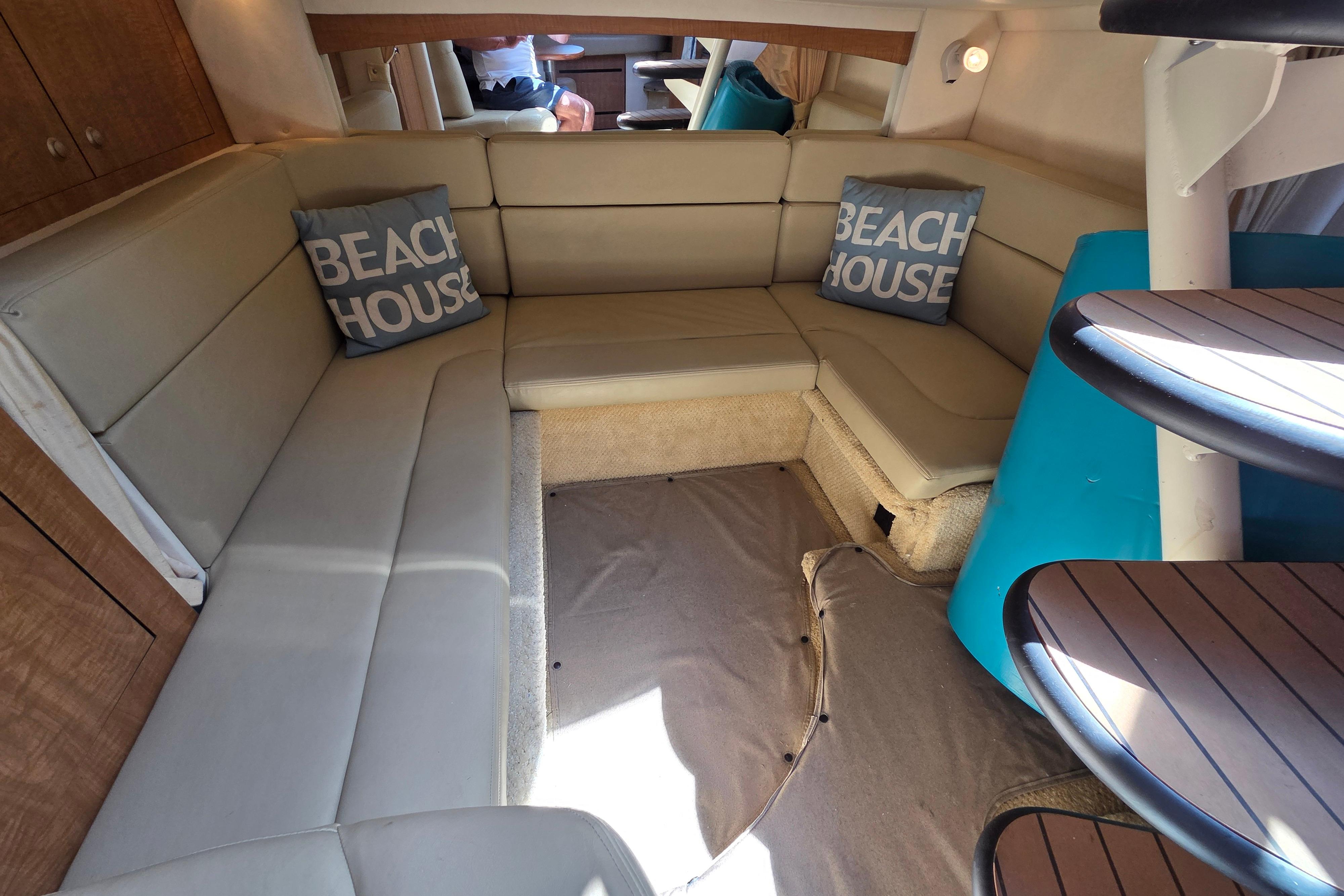 Interior of 2006 Sea Ray Sundancer 320 with beige seating and "Beach House" pillows.
