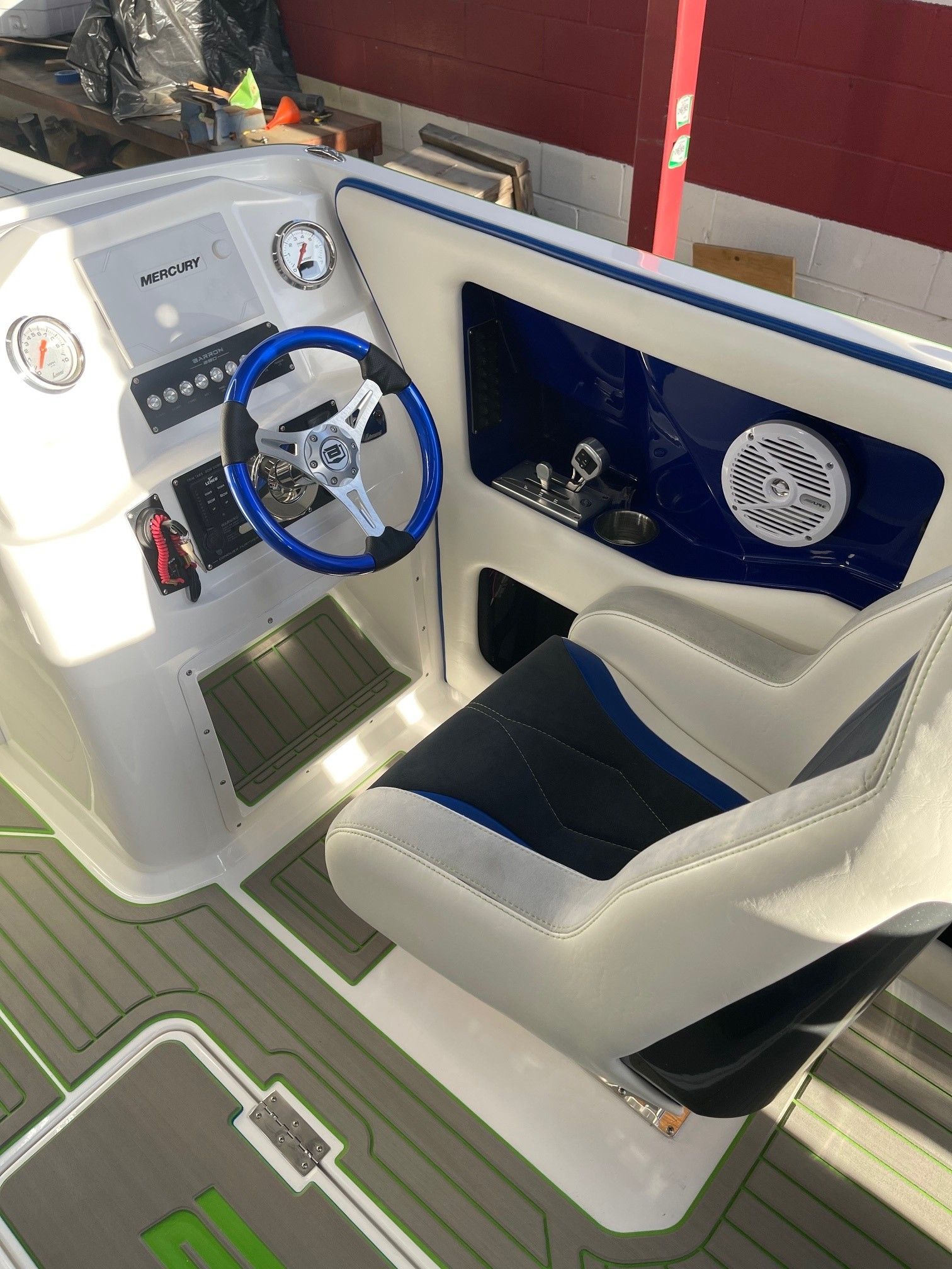 Interior of a 2021 Custom Barron 290s boat with steering wheel and seat.