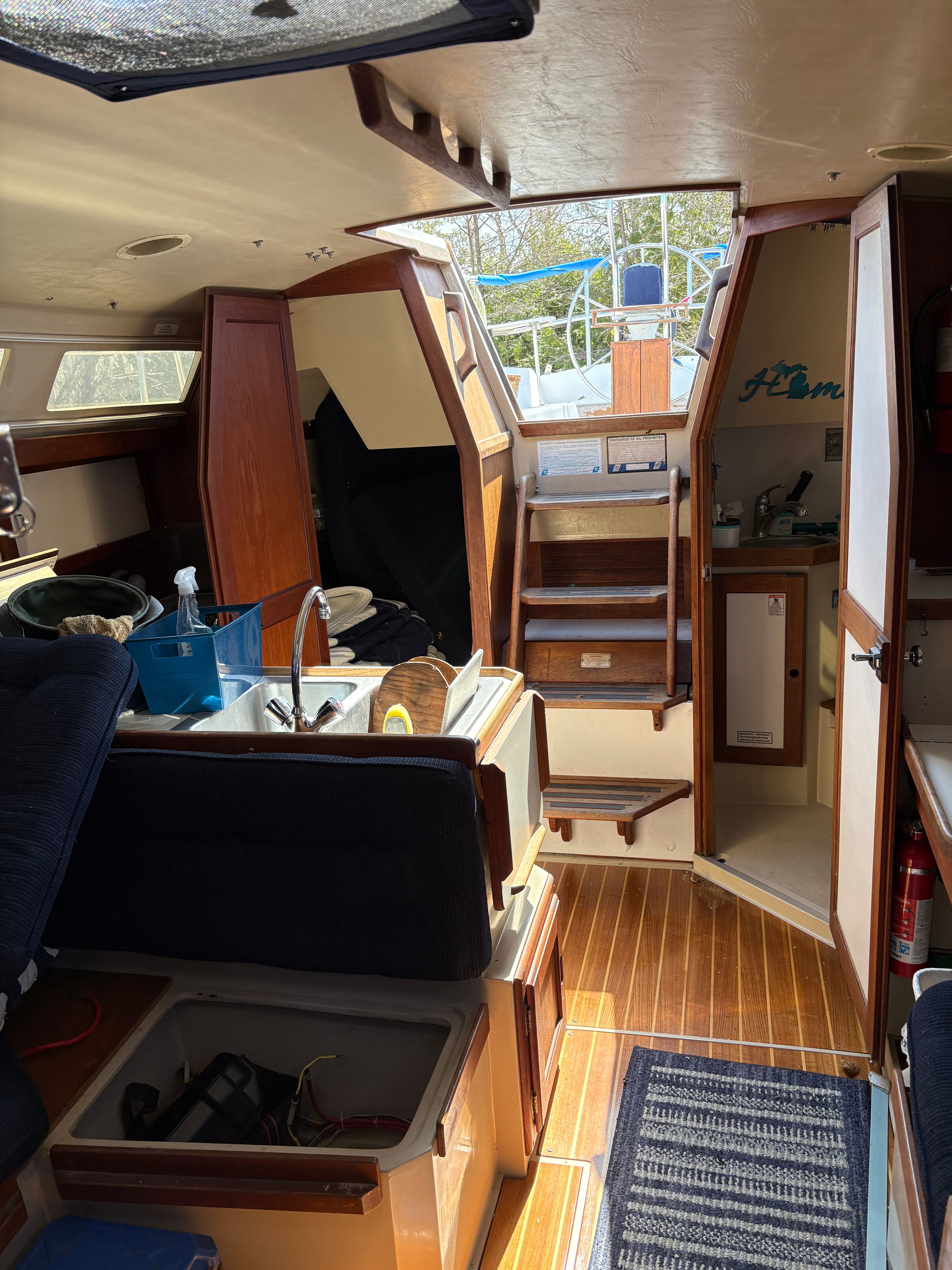 Interior of a 1989 Catalina 34 with wooden floors and stairs leading to the deck hatch.