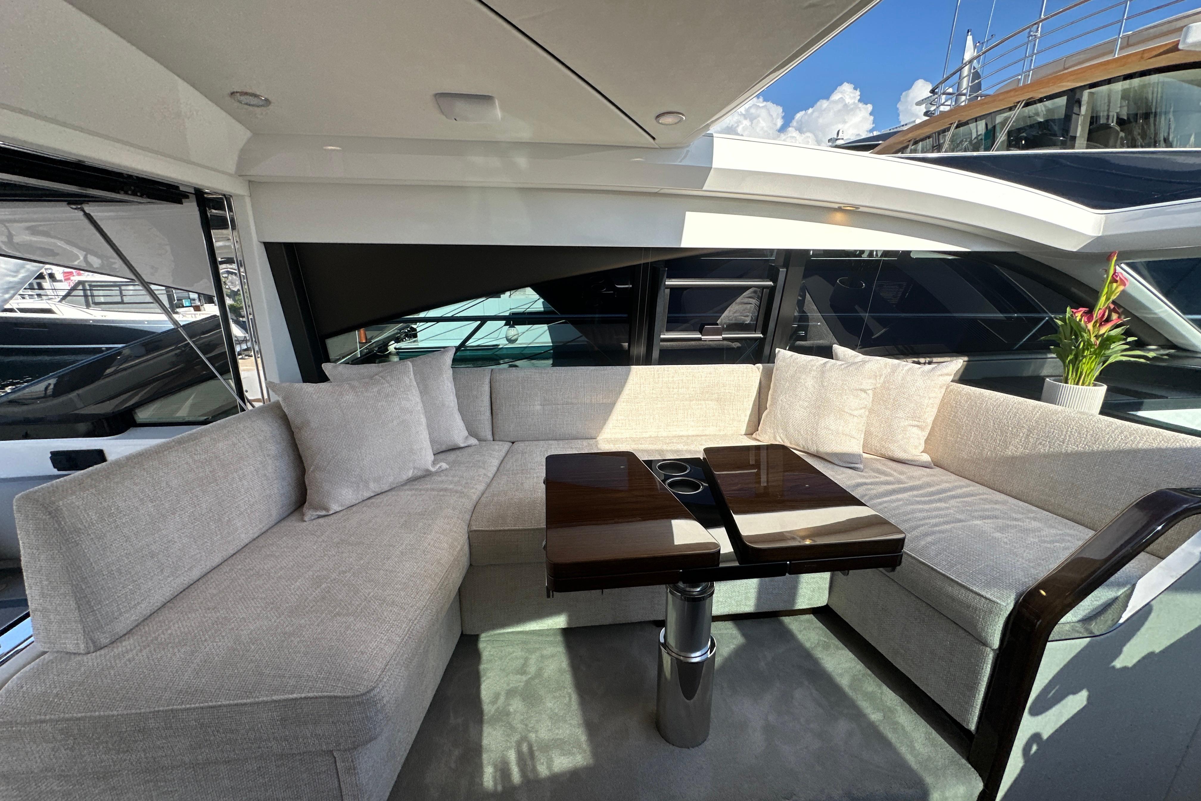 Luxurious seating area on 2026 Fairline Targa 47 GT yacht with elegant table and cushions.