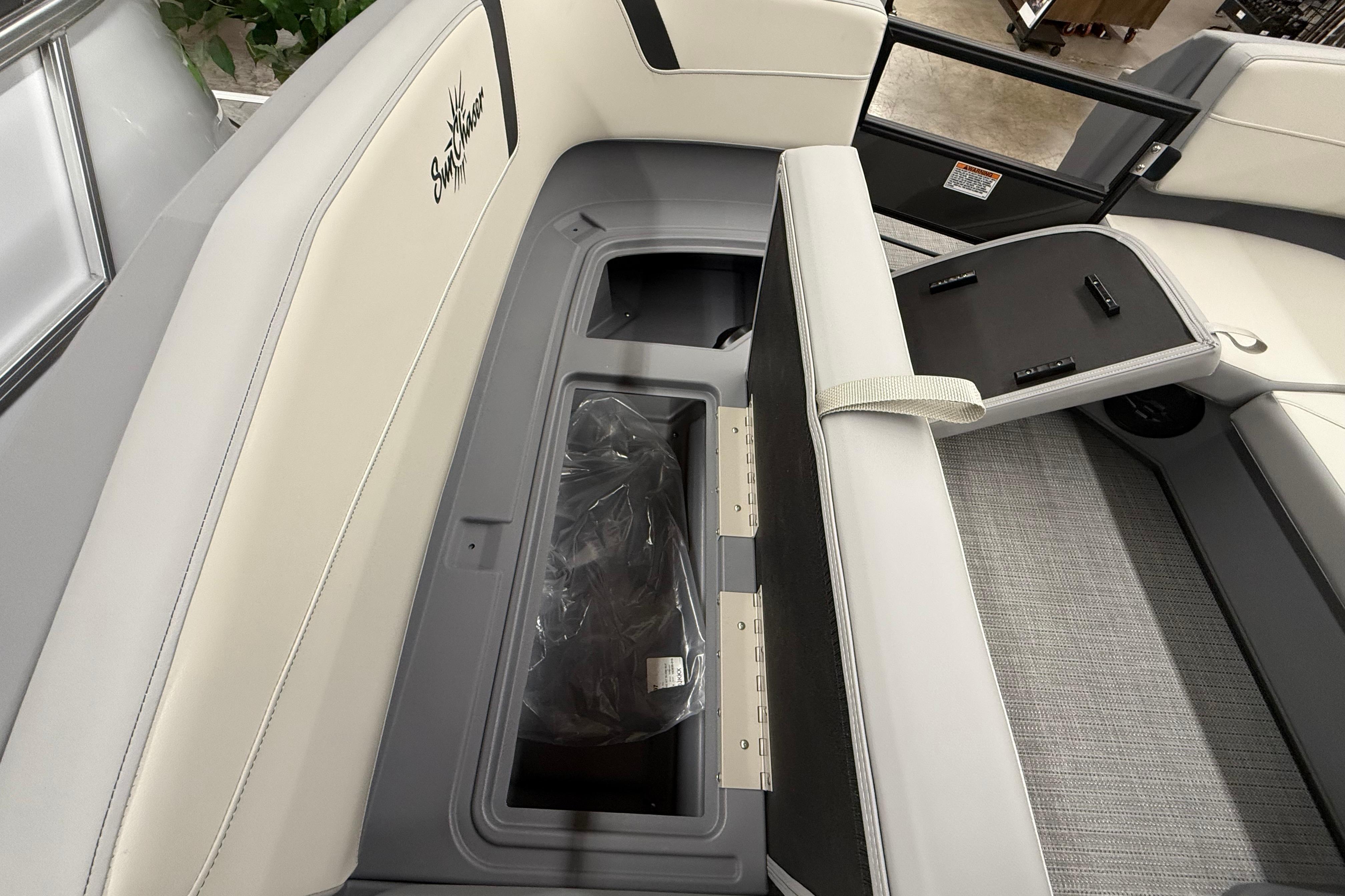 2025 SunChaser Lucerne 22 LR DH boat interior with storage compartment and seating.