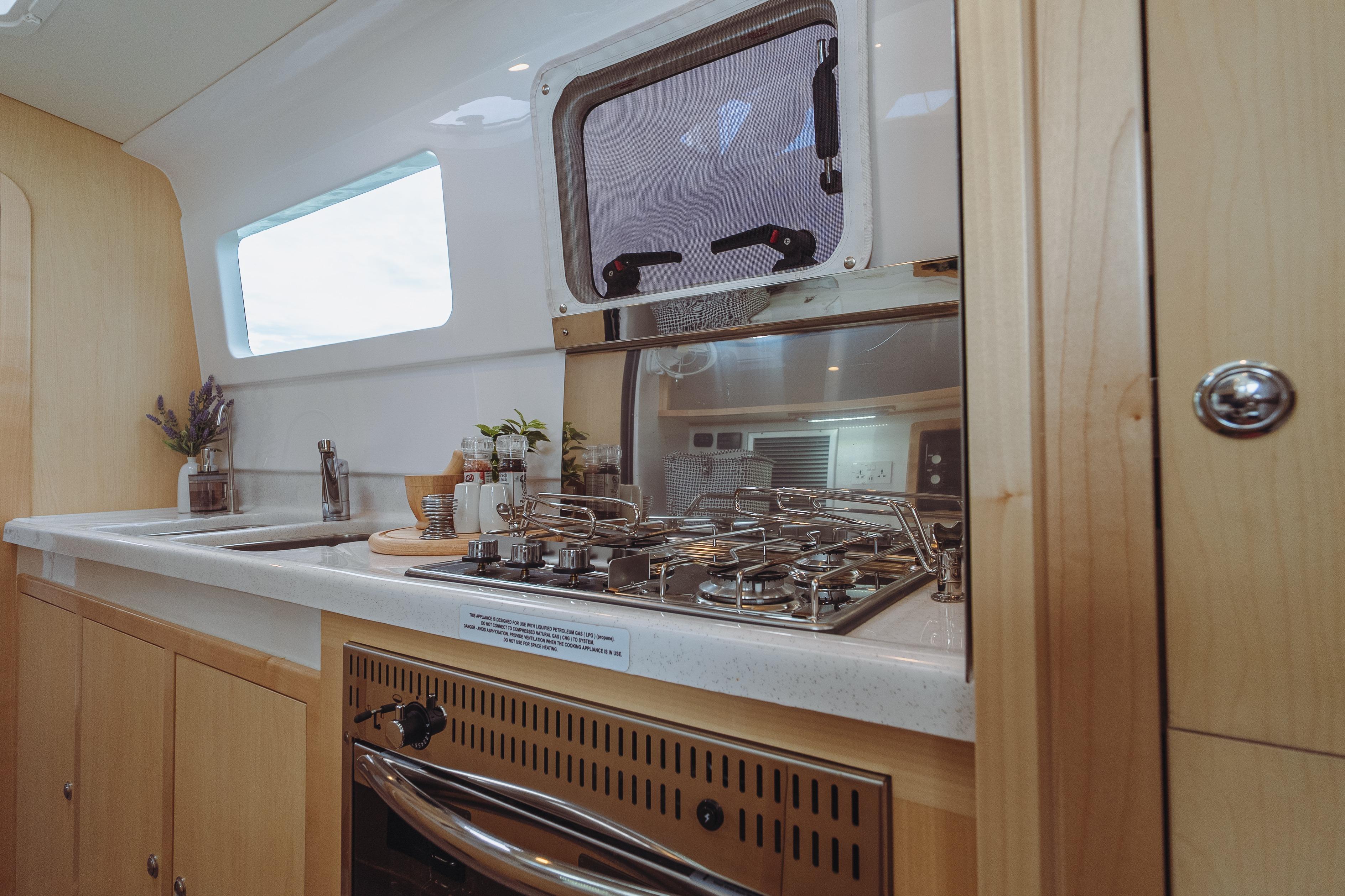 Modern kitchen interior of 2026 Seawind 1160XL yacht with stove and sink.