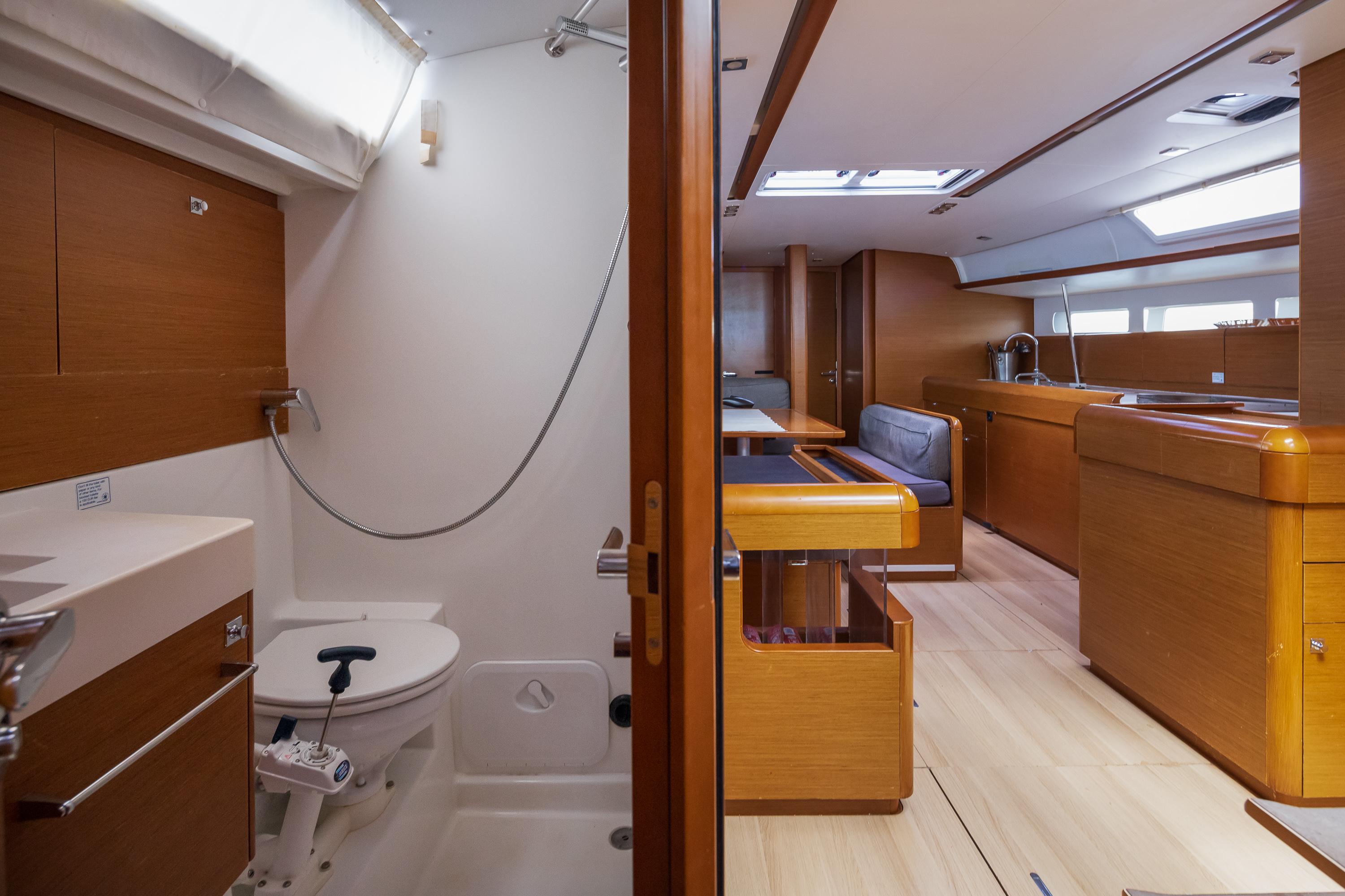 Interior of 2018 Jeanneau Sun Odyssey 519 yacht, featuring bathroom and spacious living area.