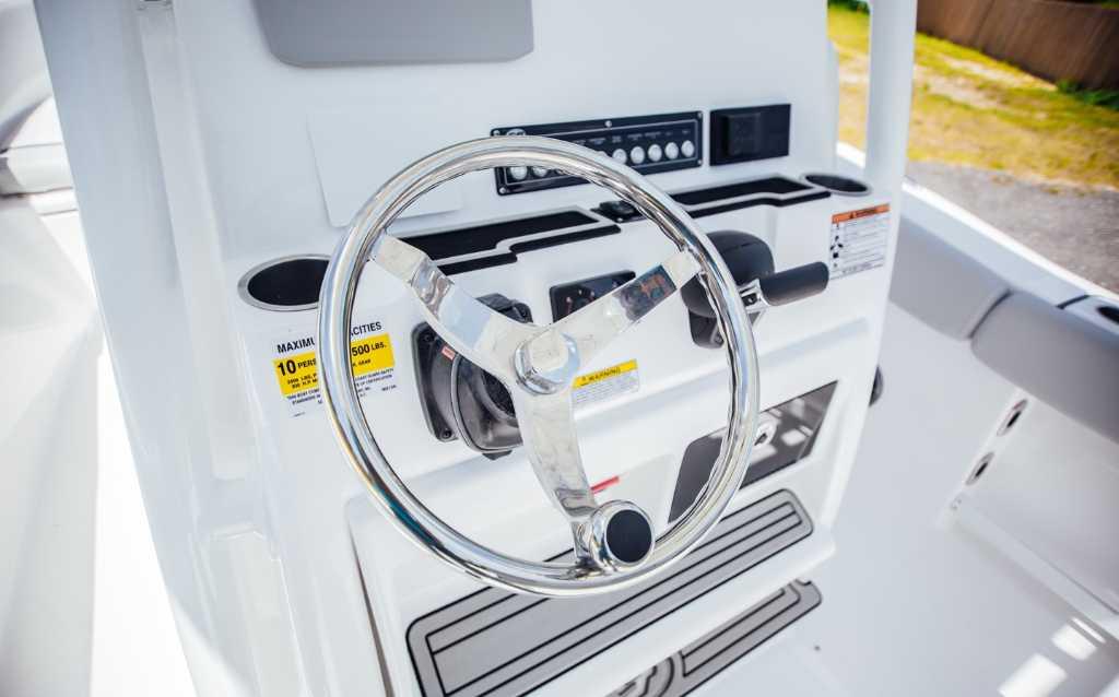 Steering console of 2021 Sea Fox 248 Commander boat with chrome wheel and controls.