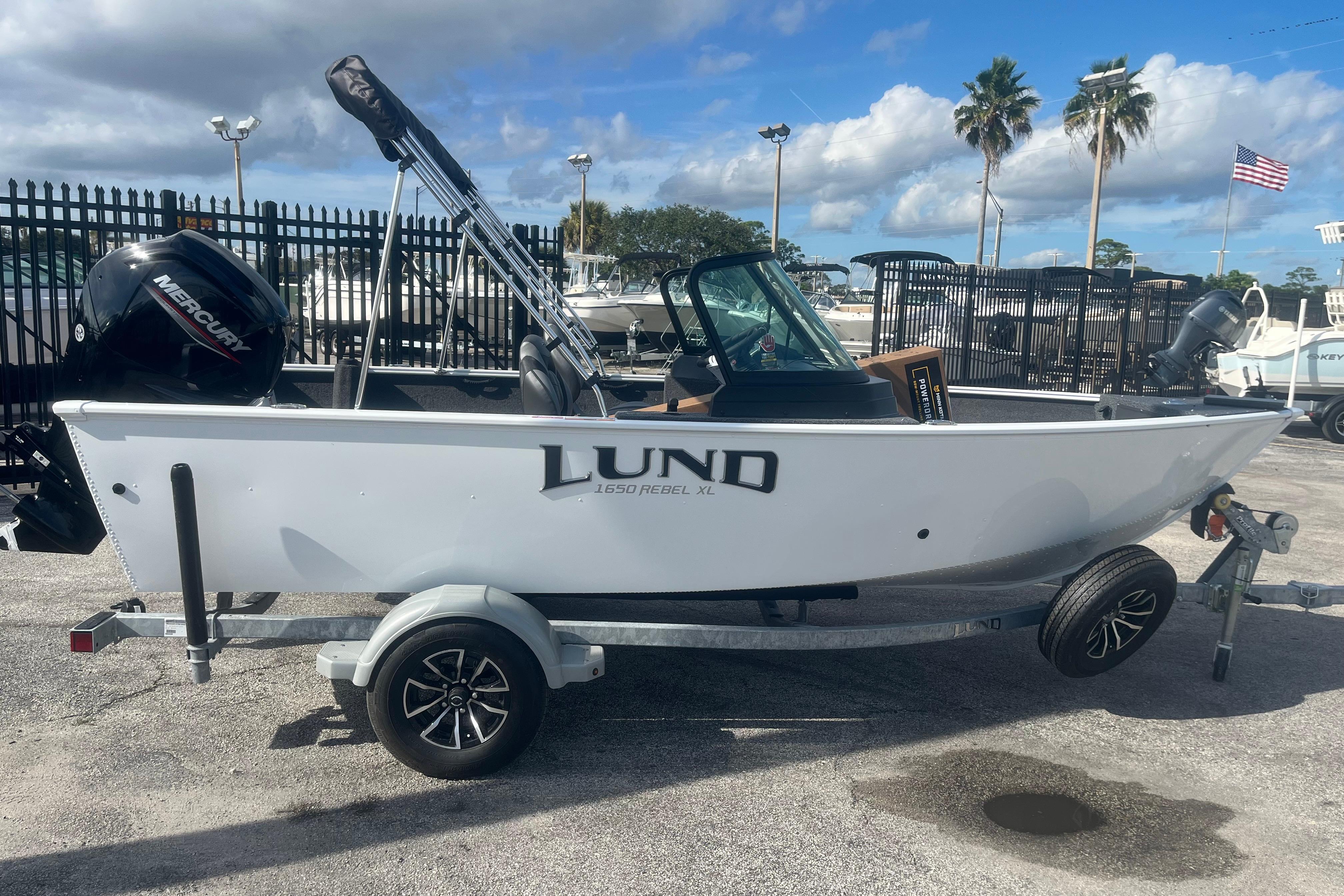 2026 Lund 1650 Rebel XL Sport boat on trailer, parked outdoors under blue sky.