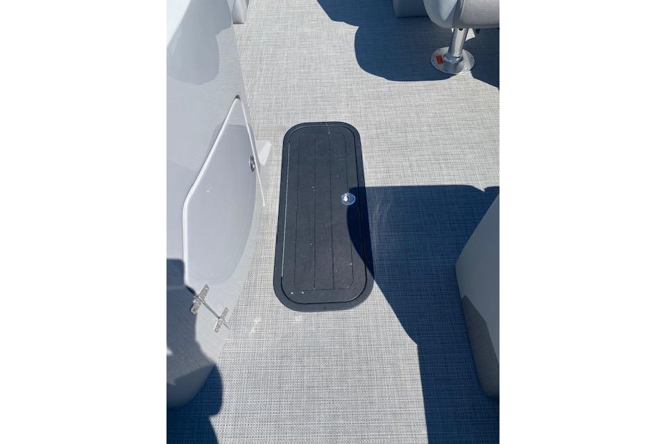2026 Manitou 23 AURORA RF VPII 575 boat deck with storage hatch.