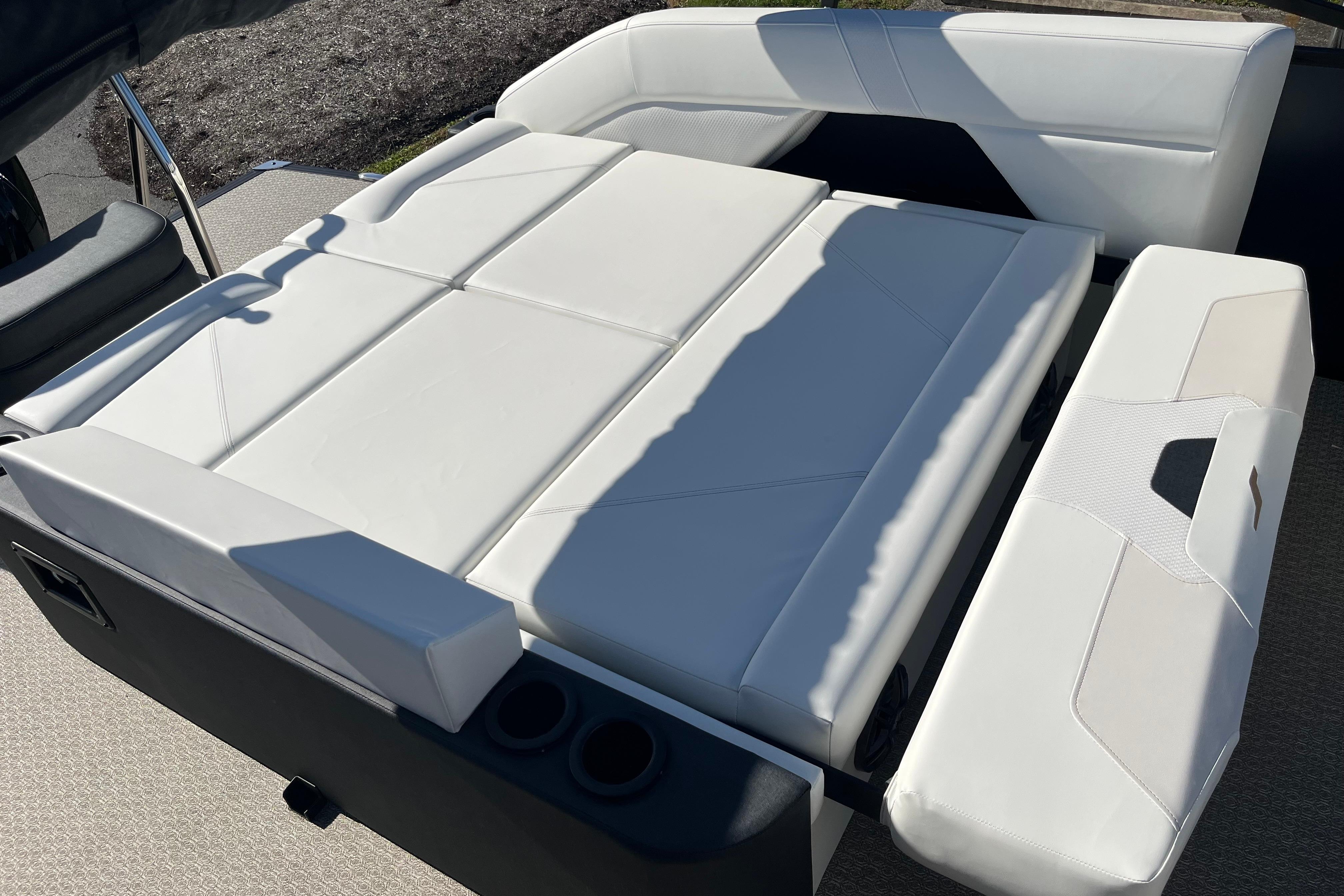 Evotti 523CS 2026 boat interior with white cushioned seating and cup holders.