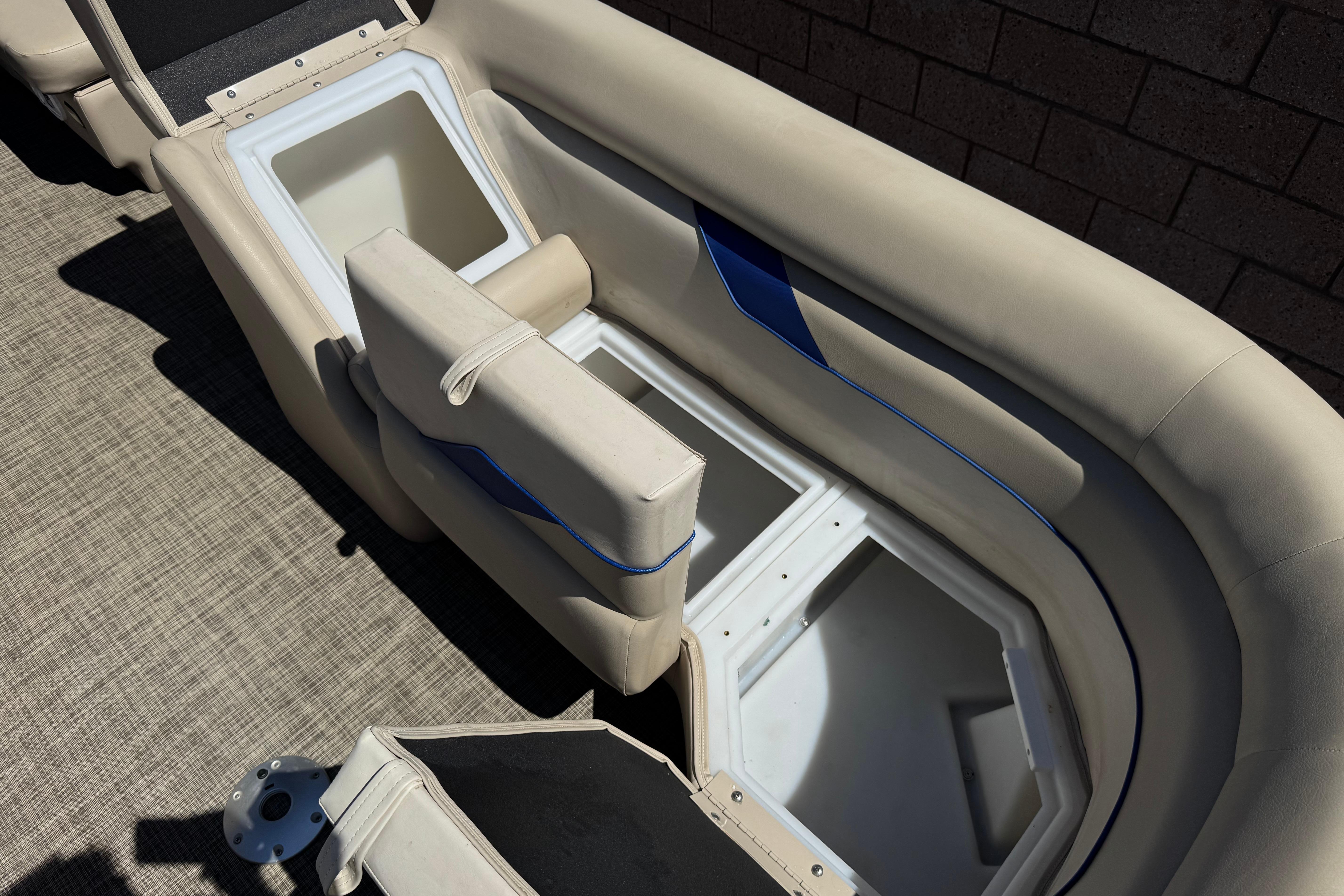 Open storage compartments on a 2021 SunCatcher Select 20RCX boat with beige seating.