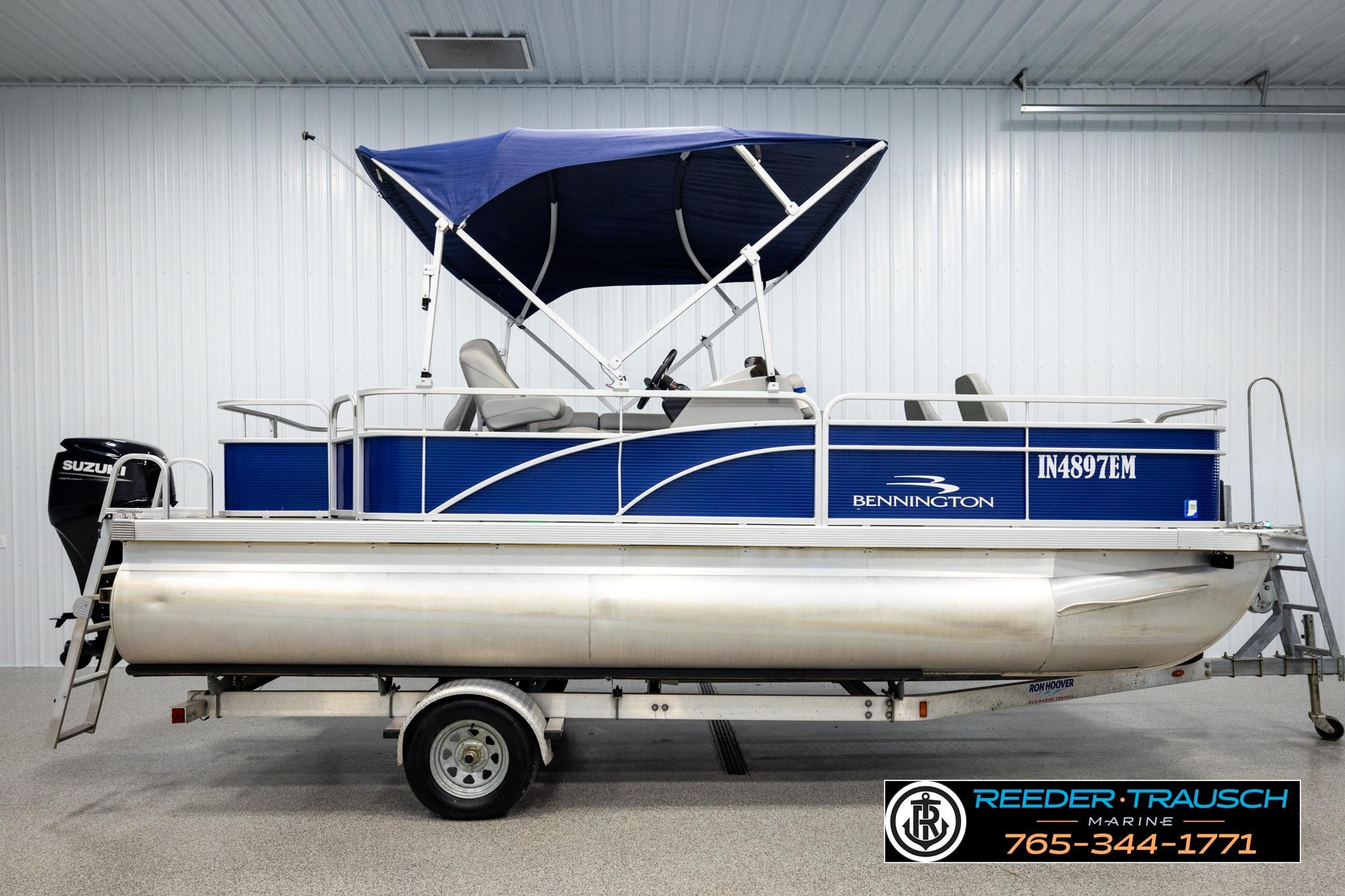 2021 Bennington 20 SV pontoon boat with blue canopy and Suzuki motor on trailer.