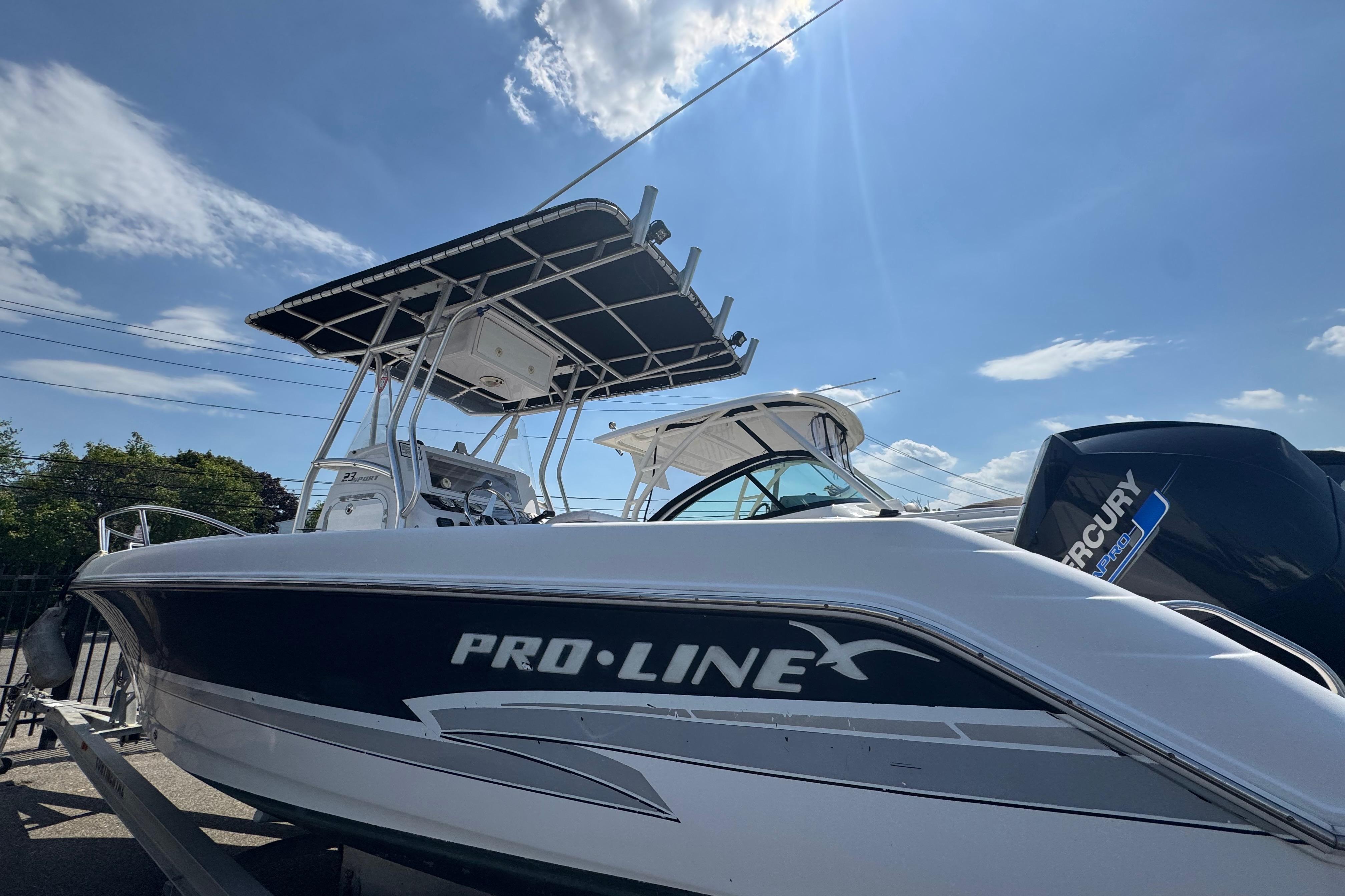 2002 Pro-Line 23 Sport boat with Mercury engine under a clear blue sky.