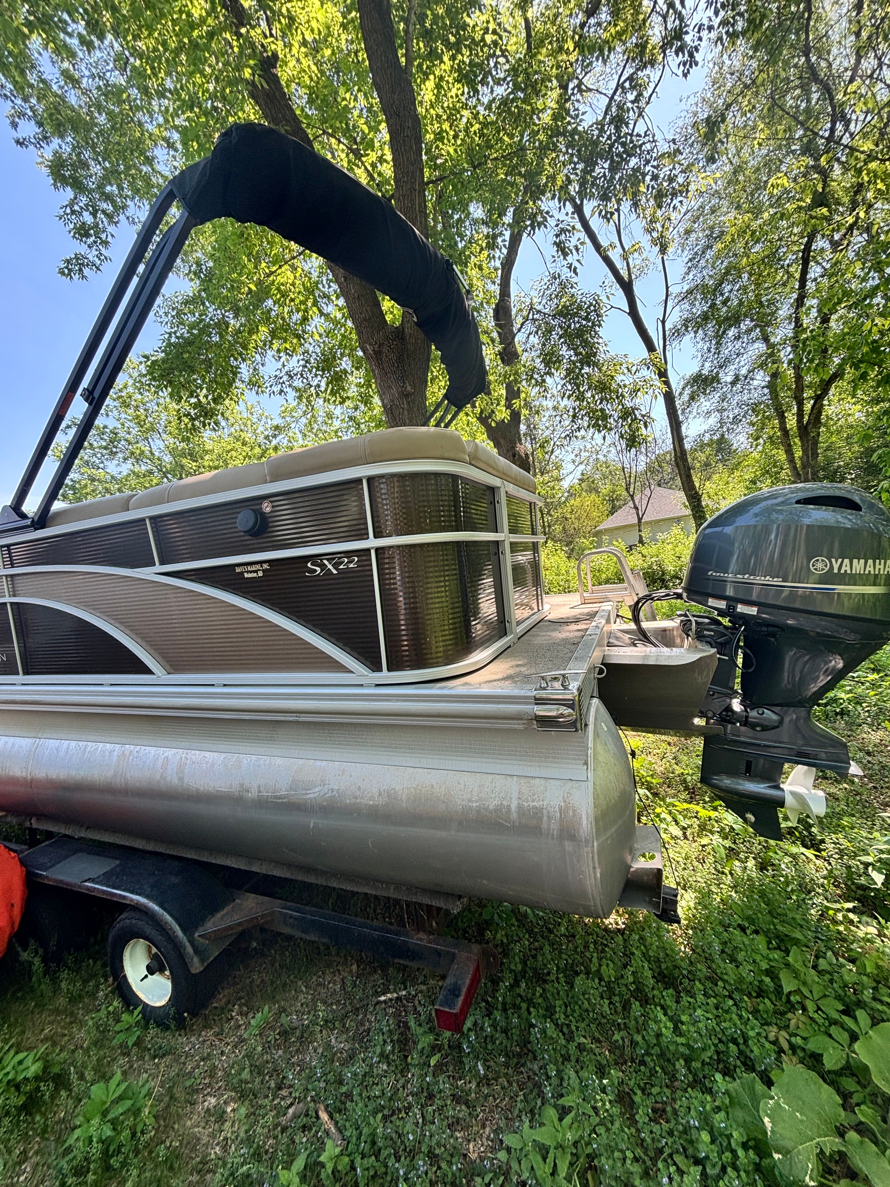 2016 Bennington 22 SLX pontoon boat with Yamaha motor in greenery.