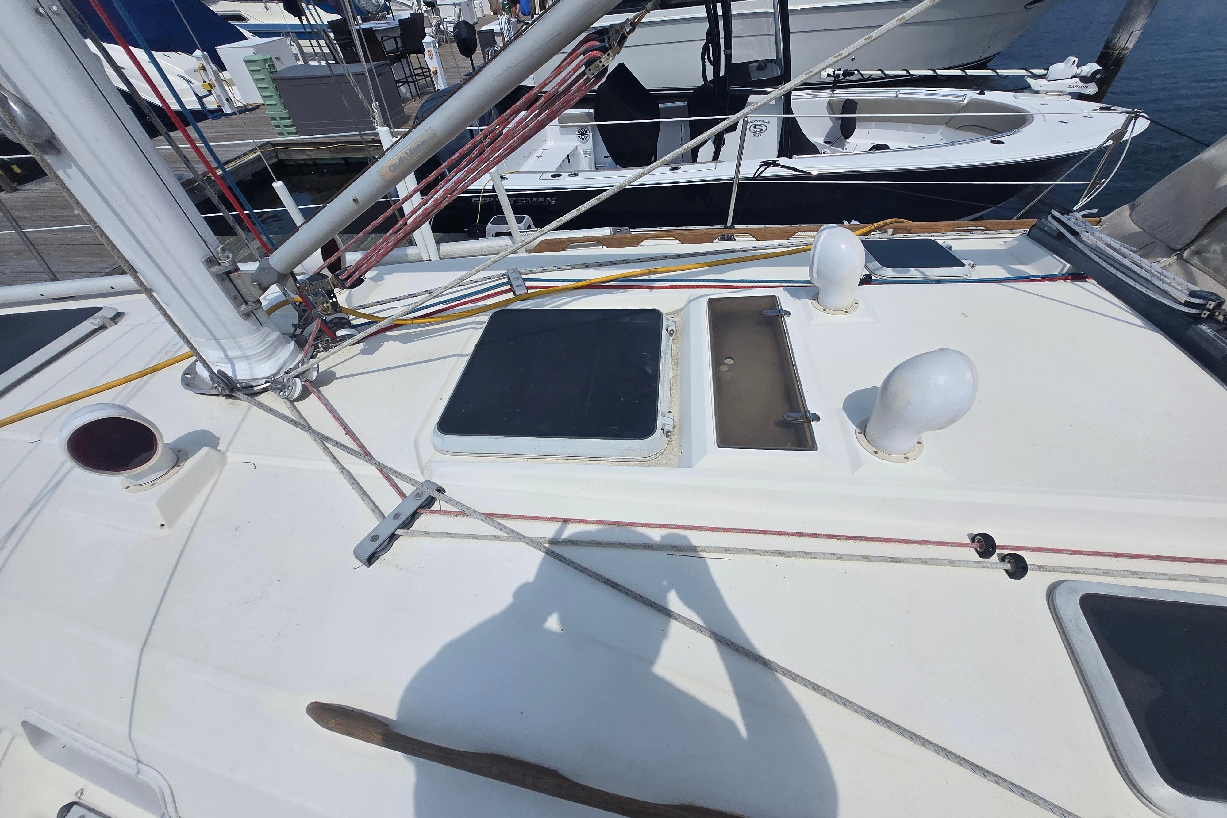 Deck of 1988 Sabre 38 sailboat with rigging and hatches at marina.