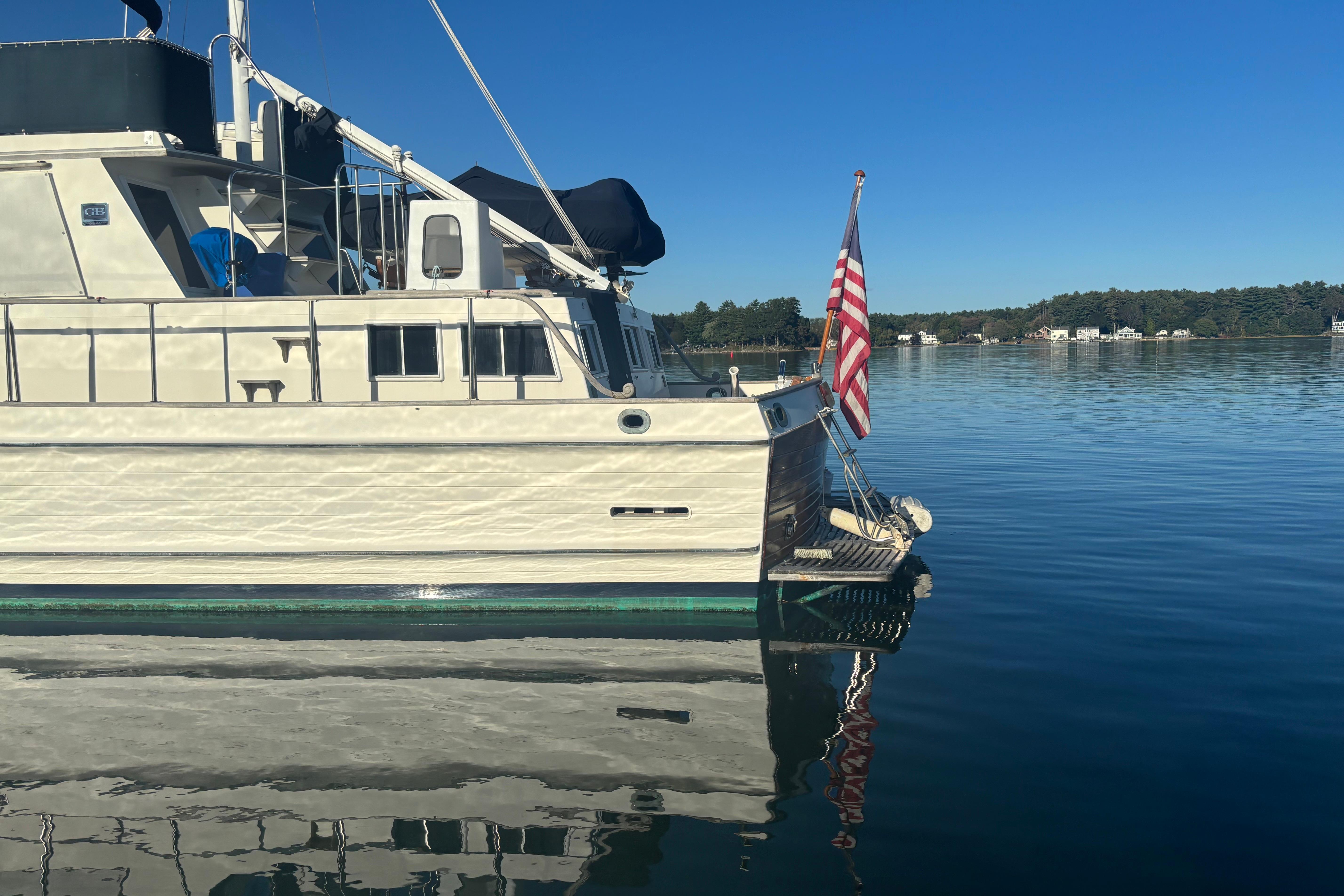 1989 Grand Banks 46 Classic yacht on calm water with American flag.