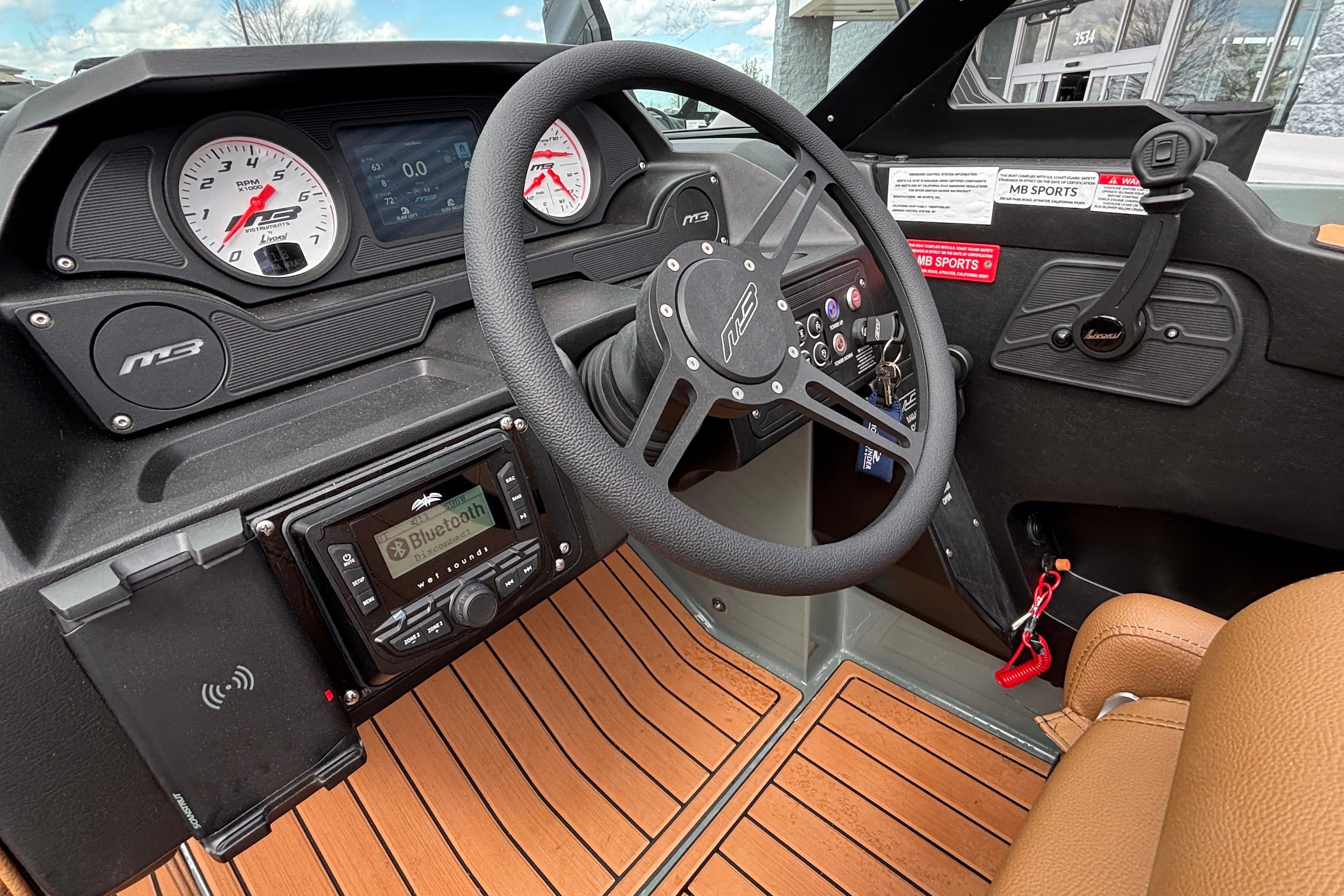 2026 MB B52 23 Classic boat dashboard with steering wheel, gauges, and Bluetooth stereo system.