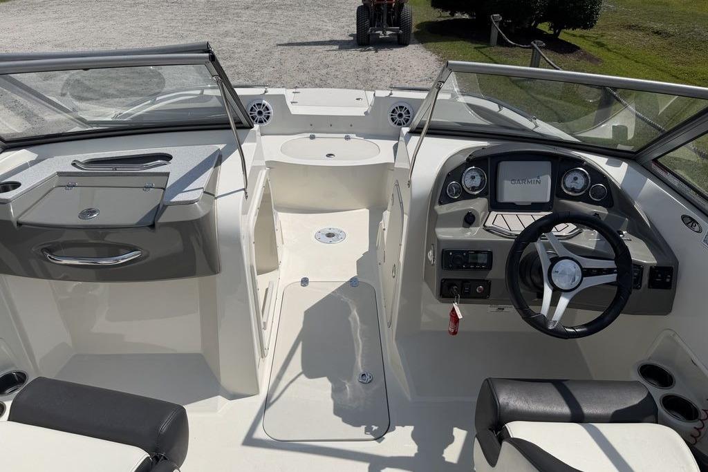 2019 Stingray 201 DS boat interior with steering wheel, dashboard, and seating area.