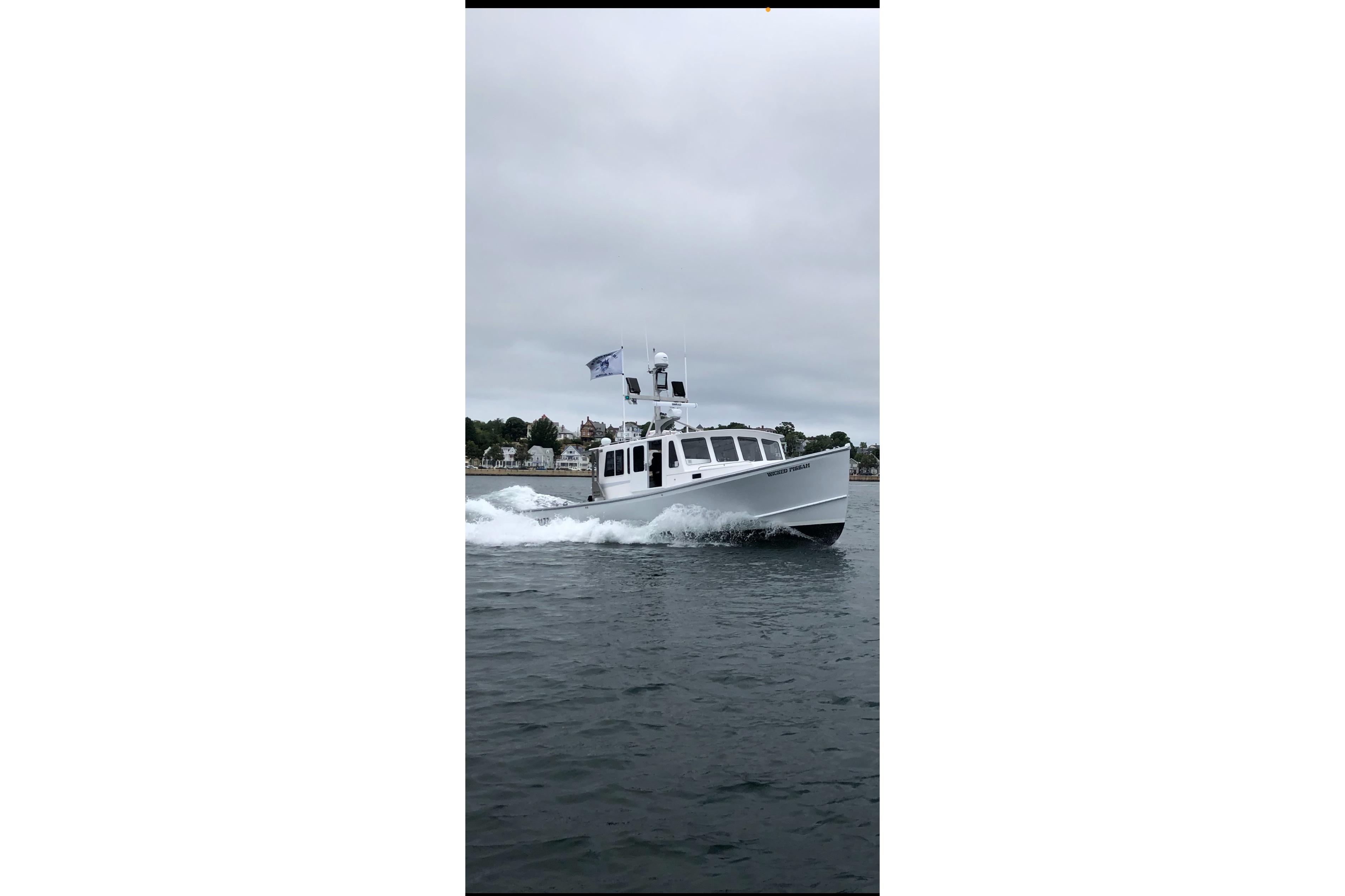 2018 H&H Marine Osmond Beal boat cruising on a calm, overcast day.